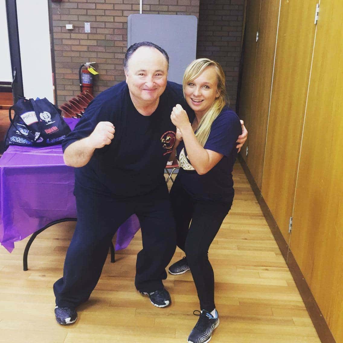 Melanie Ventura (right) with Deputy Police Chief and self-defense instructor Boyd Lyons (left) posing with their fists, a technique taught in the class. Photo by Carlie Madlinger 