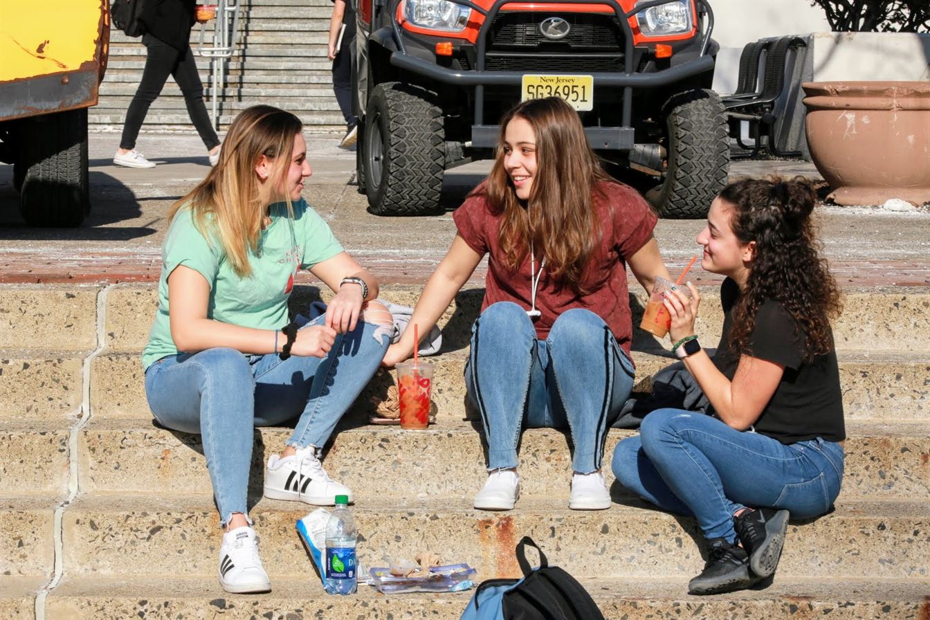 From left to right: Sophomore biology major Alex Carlucci, junior television and digital media major Mandonnah Mahallati and junior family science and human development major Frankie Racioppi chat on the steps of the Student Center. Olivia Kearns | The Montclarion
