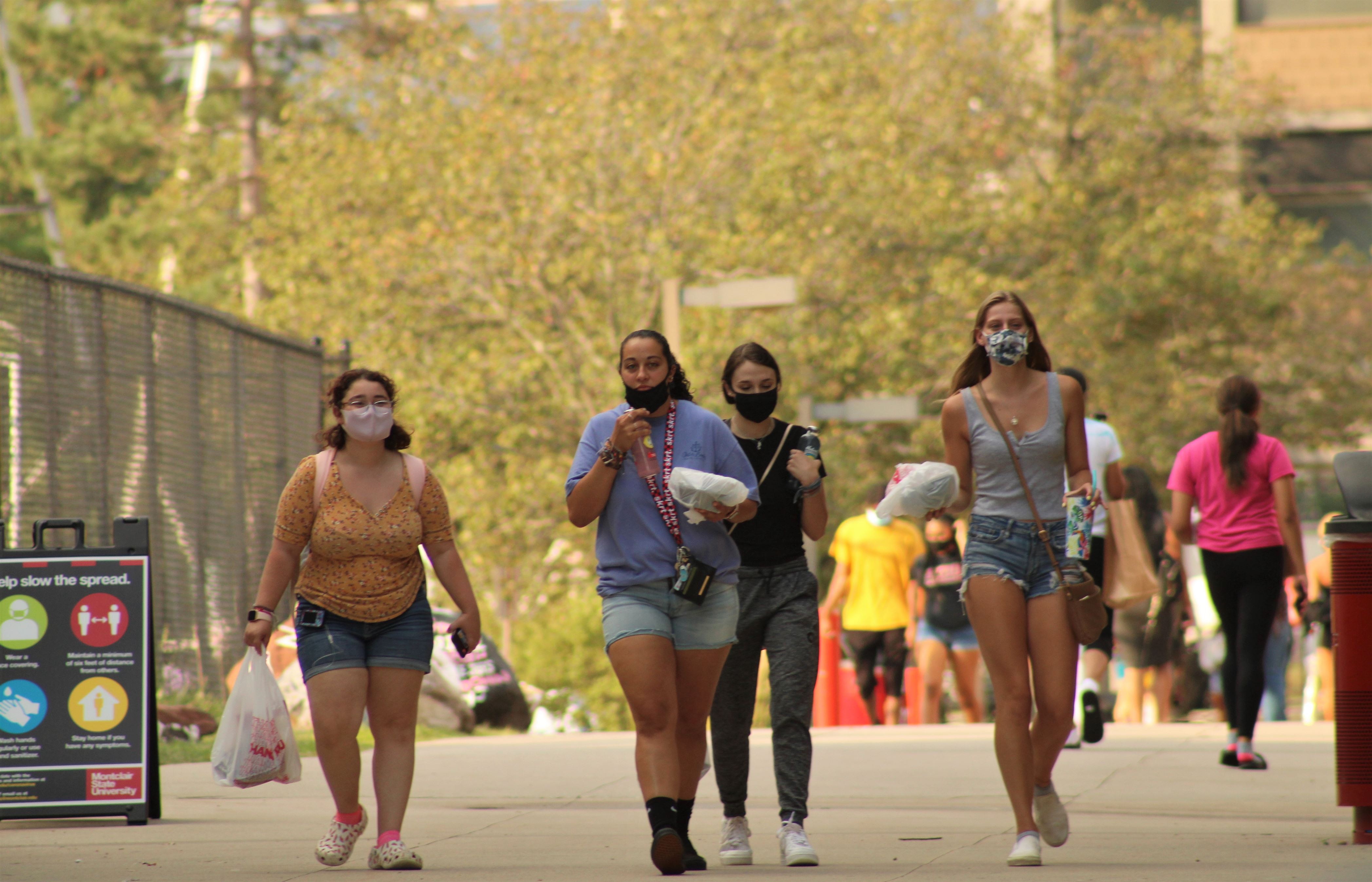 Students walk by the student center with food in hand. Corey Annan | The Montclarion