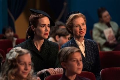 Sarah Paulson and Cynthia Nixon sit side-by-side as their characters in Ratched, viewing a children's puppet show, much to Mildred's distress. Photo courtesy: Netflix