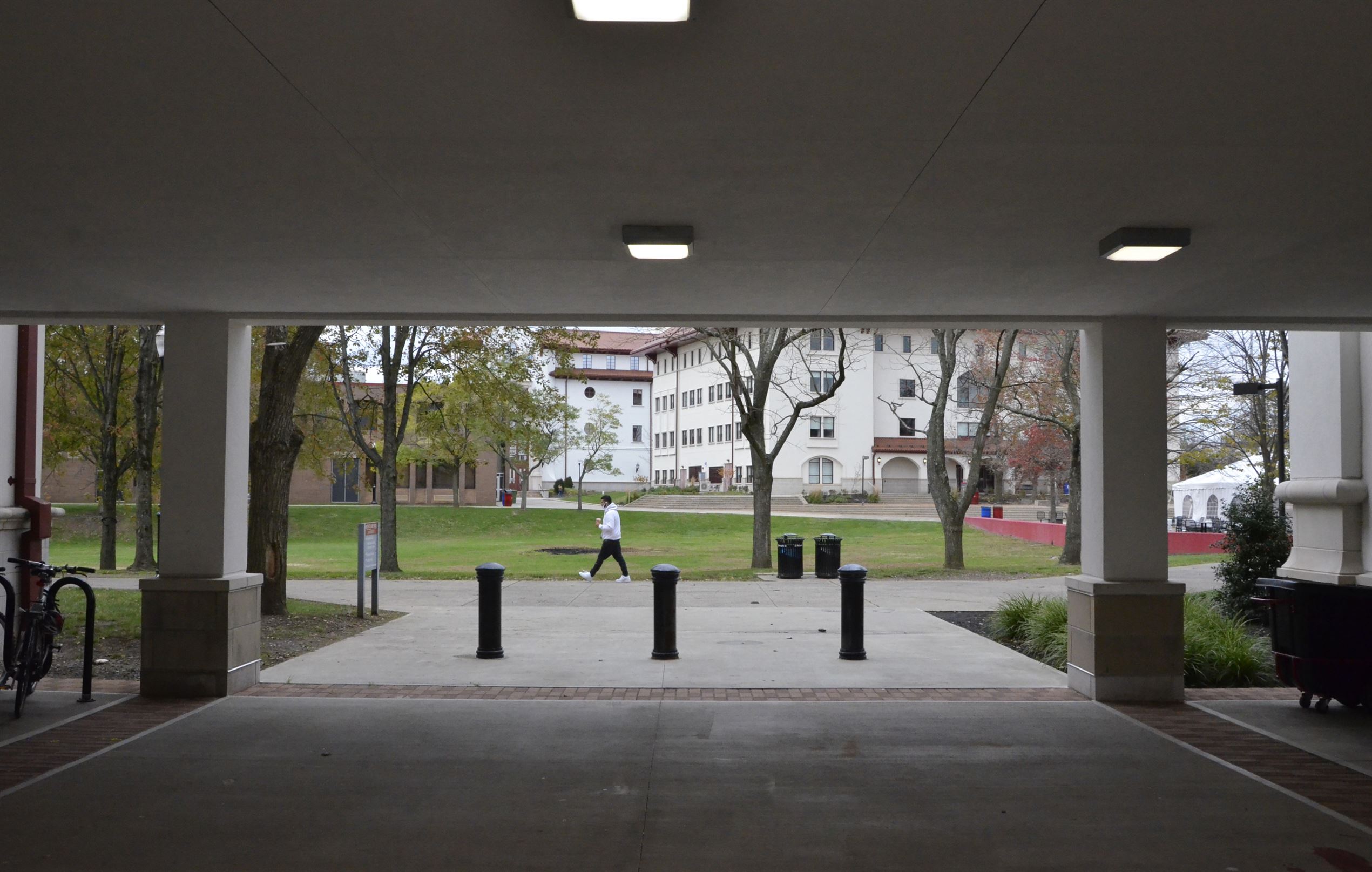A student with his cup of coffee walking past Schmitt Hall. John LaRosa | The Montclarion