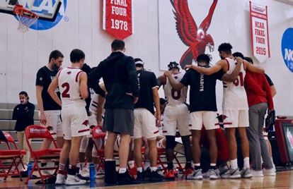 The Red Hawks huddle up around head coach Justin Potts during their Feb. 27th contest against NJCU. Photo courtesy of Julia Radley