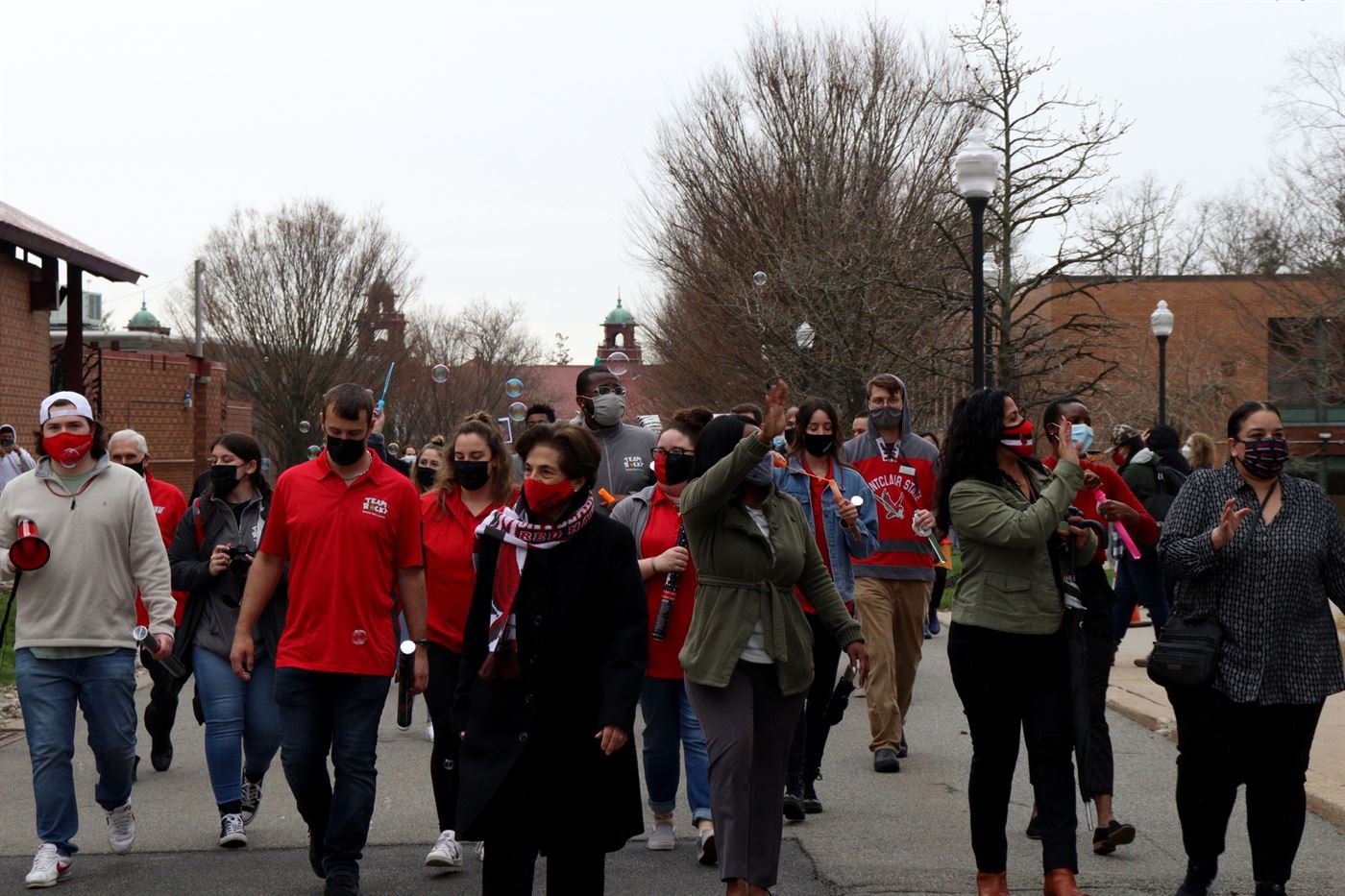 Dr. Cole leads dozens of facility members and students down University Promenade, with College Hall looming in the background. John LaRosa | The Montclarion