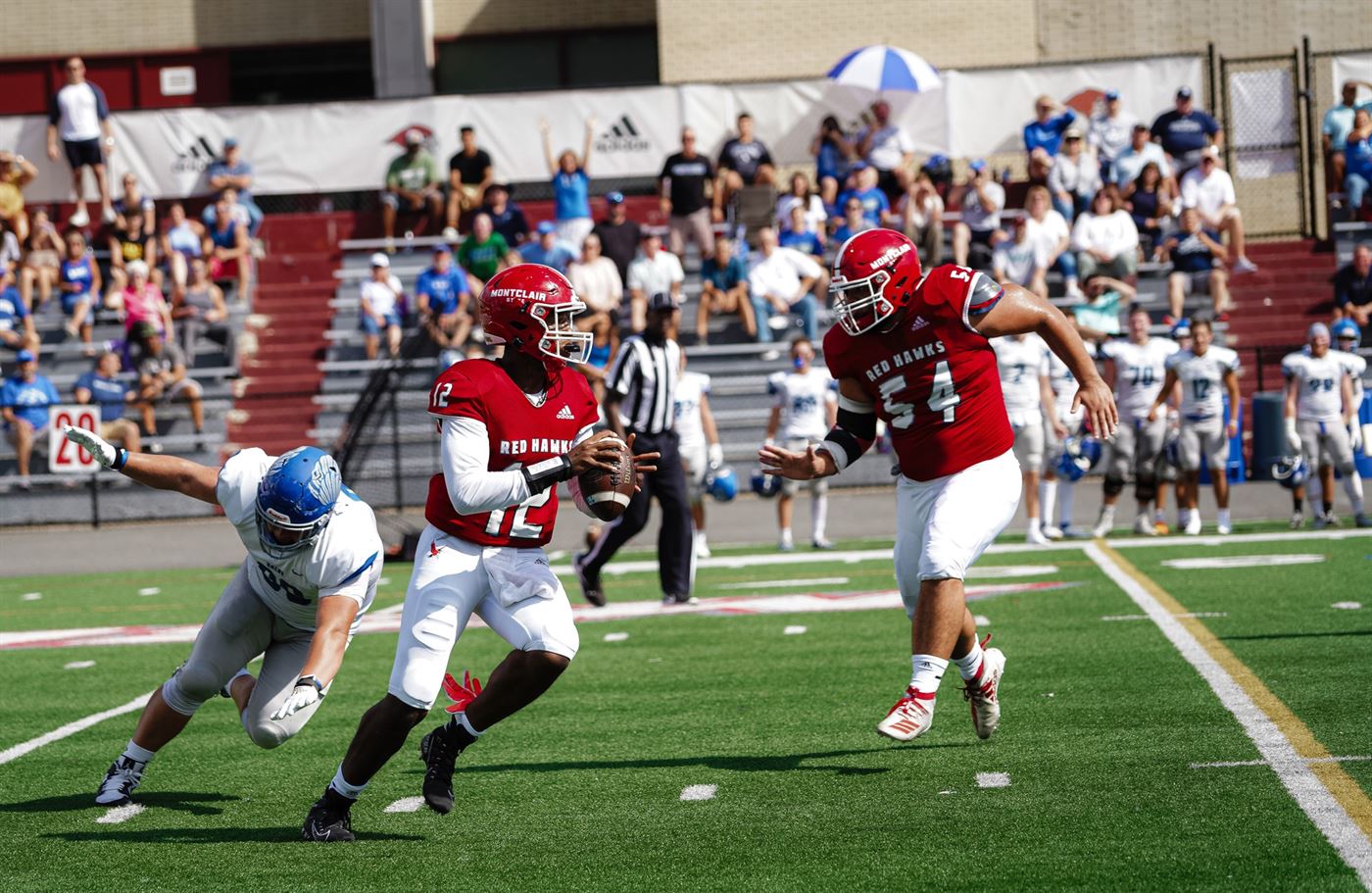 Fifth-year senior quarterback and captain Ja'Quill Burch evades a Salve Regina defender and looks downfield to pass. Photo courtesy of David Venezia