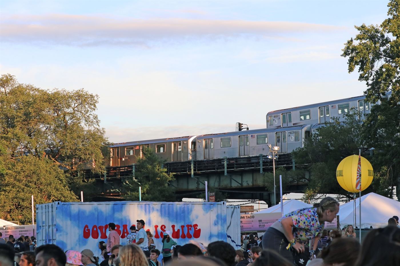 The 7 Train passes above resting festival-goers. Photo courtesy of Julian Rigg