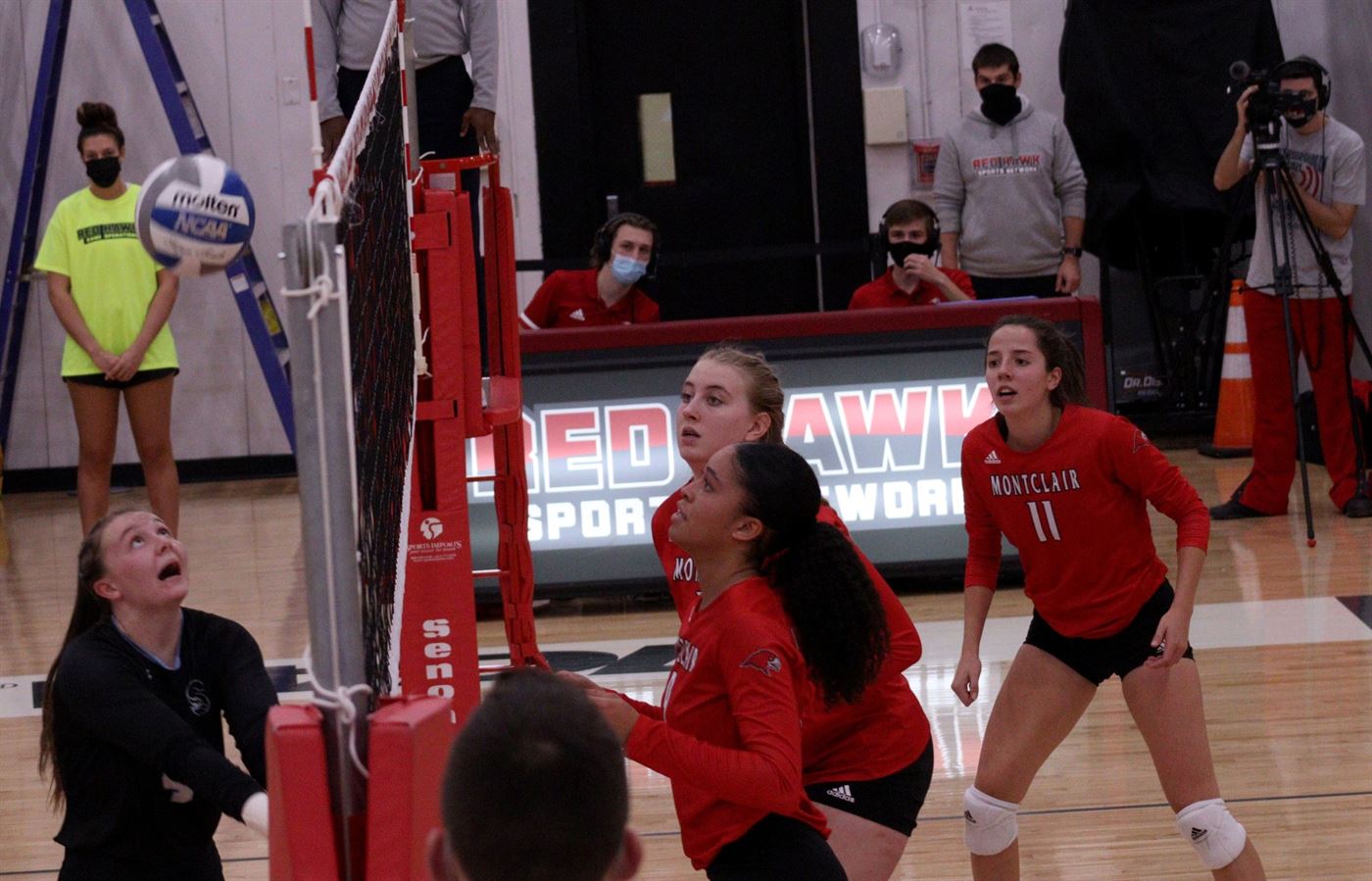 Aubrey Rentzel (left) trying to volley as the Montclair State team watches. John LaRosa | The Montclarion