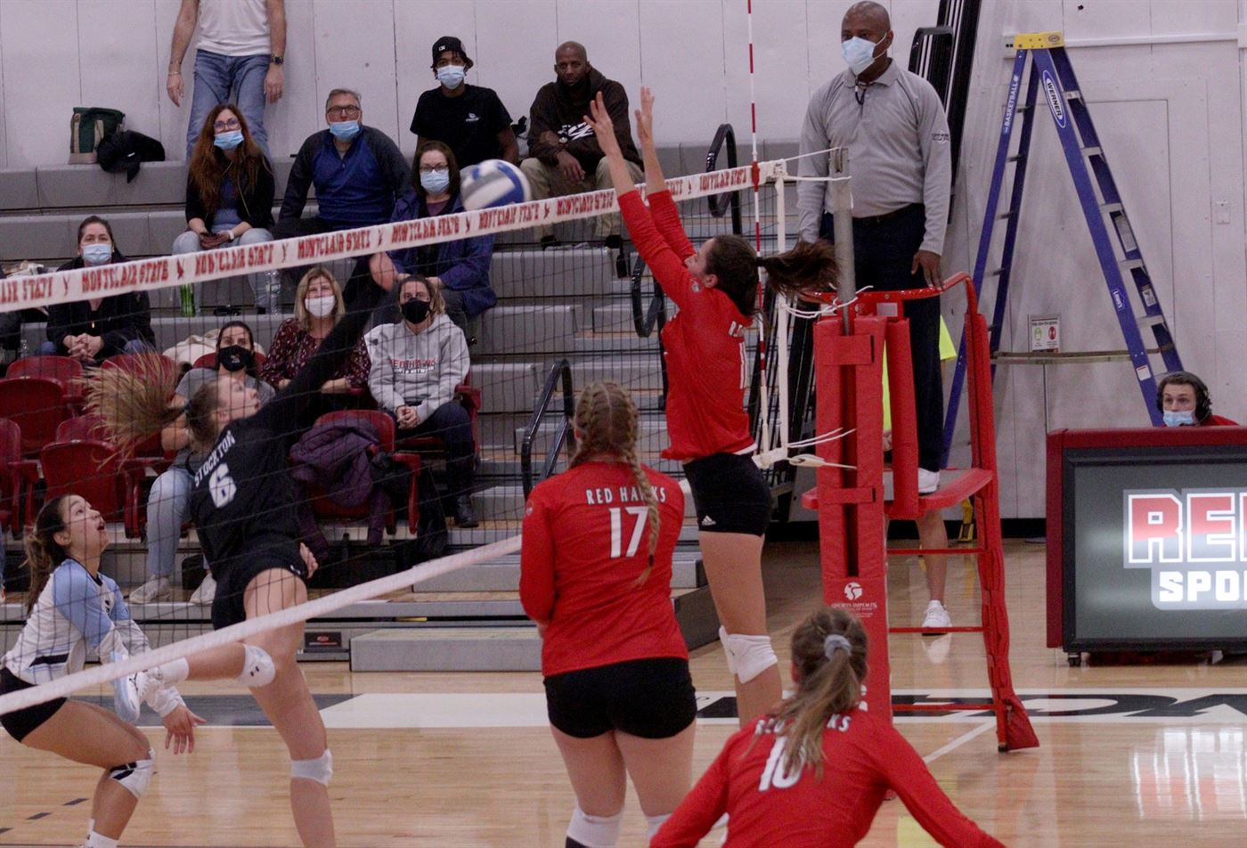 Outside hitter number six, Haley Green (left), striking the ball over the net before it is blocked by Delaney St. Pierre (middle top), ending the game. John LaRosa | The Montclarion