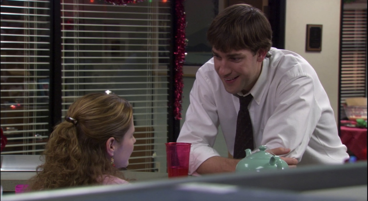 Pam (left) and Jim (right) discuss the gag gifts hidden inside her secret Santa teapot in "Christmas Party".