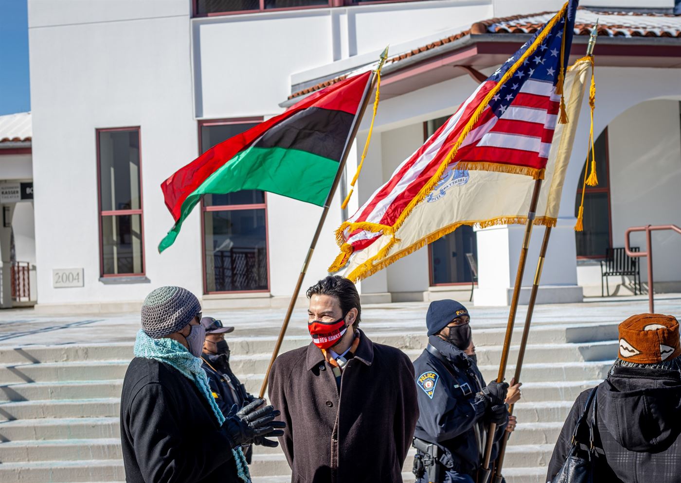 Flags flying behind Montclair State President Jonathan Koppell in honor of Black History Month during the universities annual parade. John LaRosa | The Montclarion