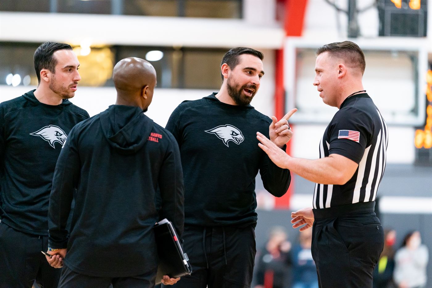 The coaches of the men's basketball team speak to the referee about a controversial call. Chris Krusberg | The Montclarion
