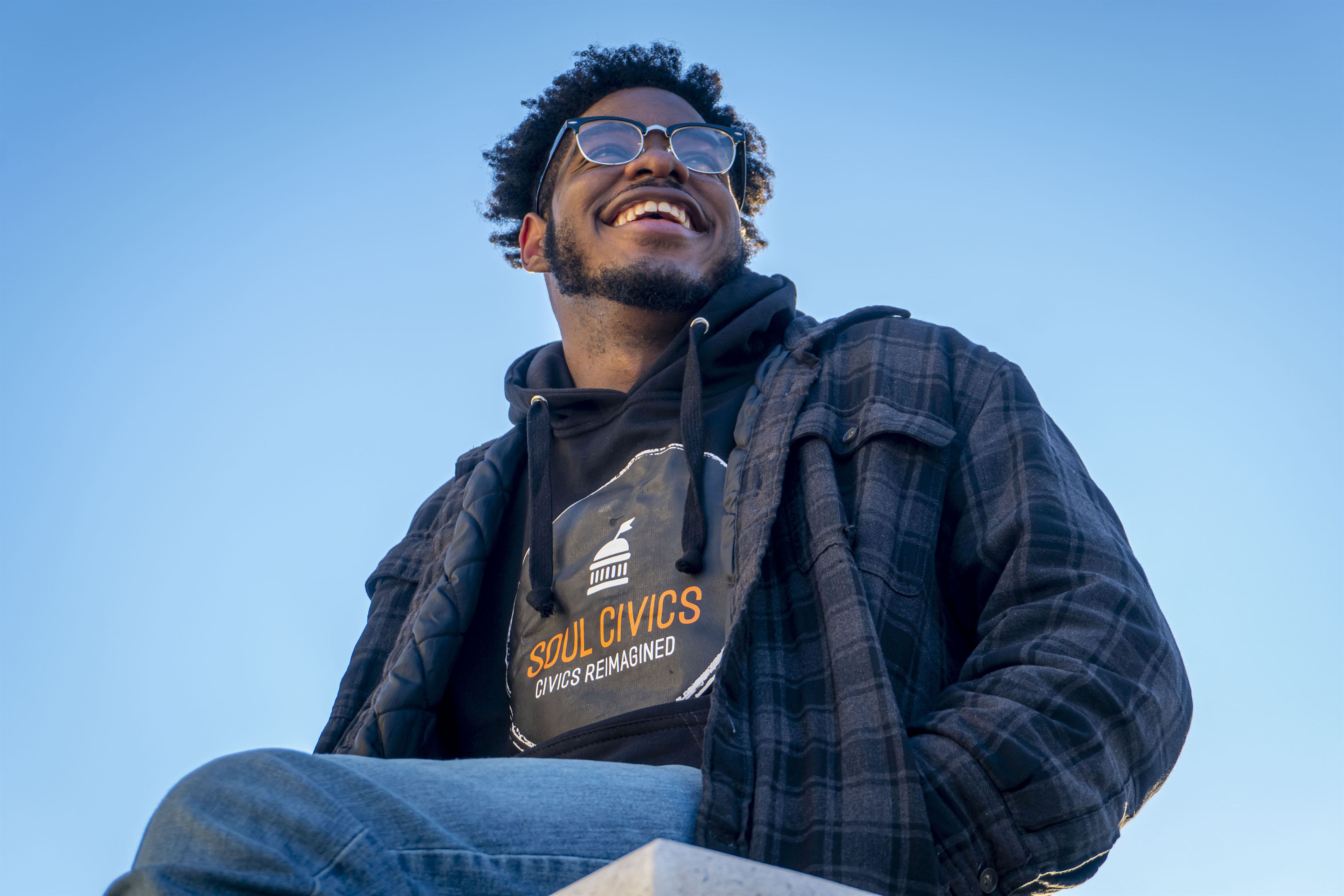 On a ledge, Jordan Stewart, a political science and spanish major, wears his "Soul Civics" sweatshirt. Lynise Olivacce | The Montclarion