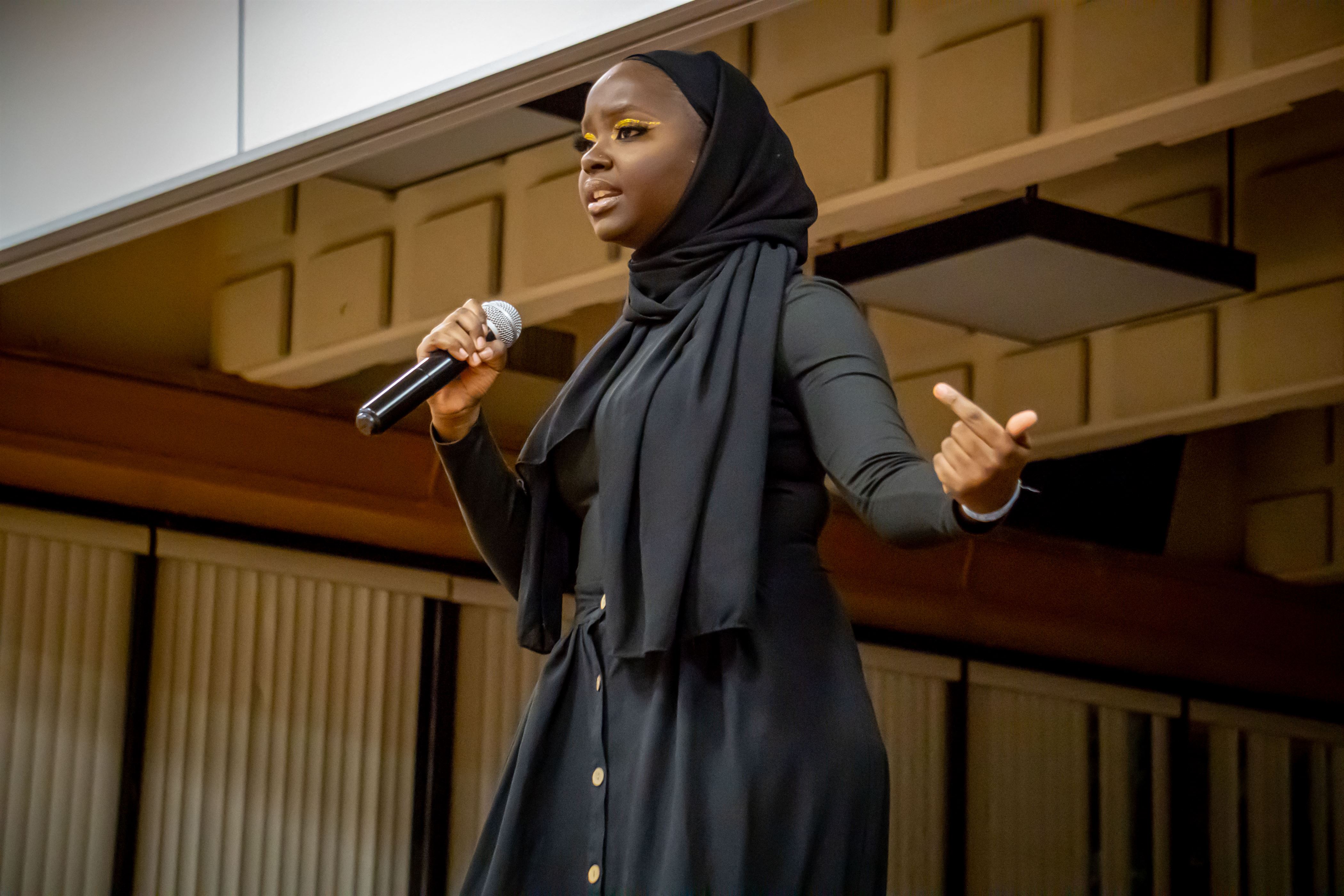 Fatoumata Amar, the new Mrs. NASO and senior fashion studies major, recites her poem during the Talent category. Lynise Olivacce | The Montclarion