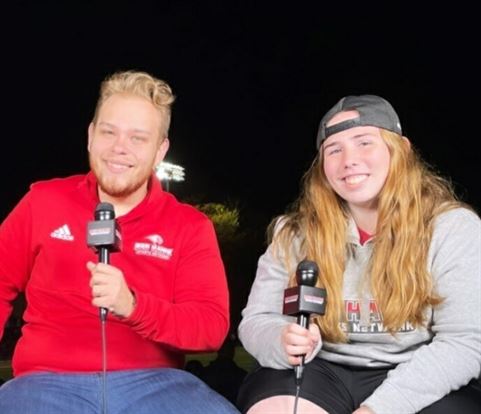 Emily Struble on the microphone with Red Hawk Sports Network director Alex Grabiec. Photo courtesy of Emily Struble