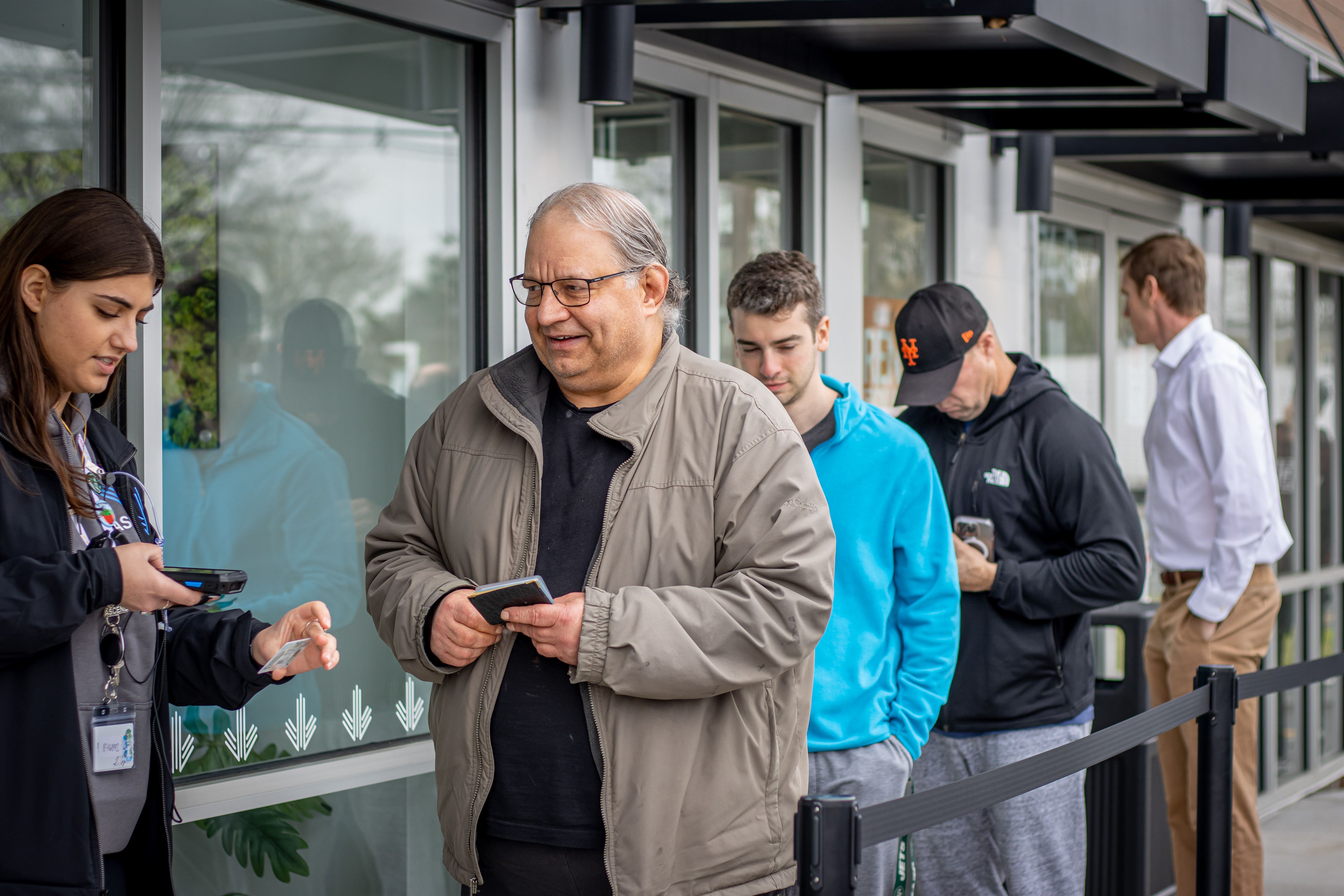 Costumers wait as they have their ID checked and scanned before entering the store. John LaRosa | The Montclarion