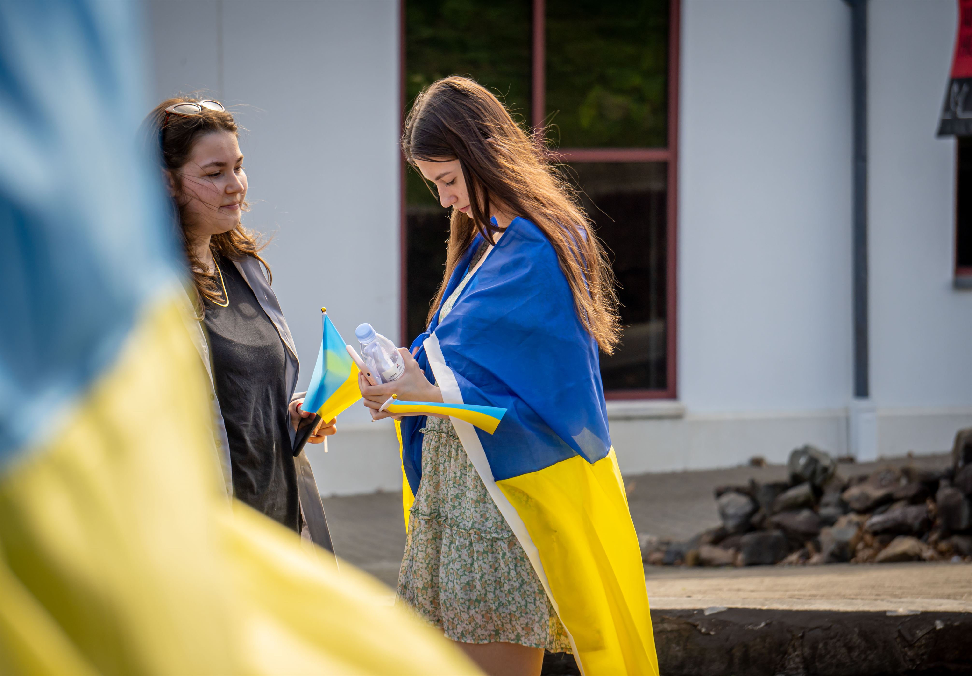 Liz Chernyshova, a psychology major and Russian minor, prays for Ukraine while wearing the countires flag. Lynise Olivacce | The Montclarion