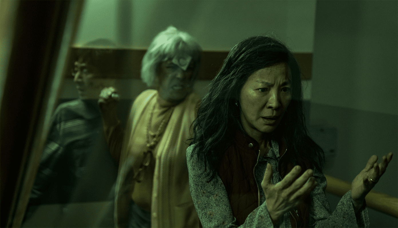Evelyn Wang (Michelle Yeoh) and Waymond Wang (Ke Huy Quan) trying to escape the wrath of a possessed IRS agent (Jamie Lee Curtis). Photo courtesy of A24