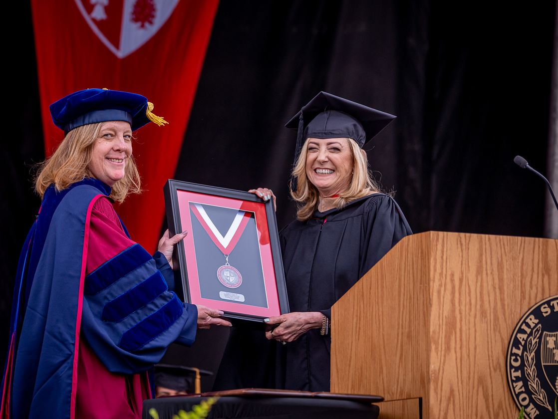 Dean Kimberly Hollister (left) presents the Distinguished Alumni Award to Helane Becker (right).