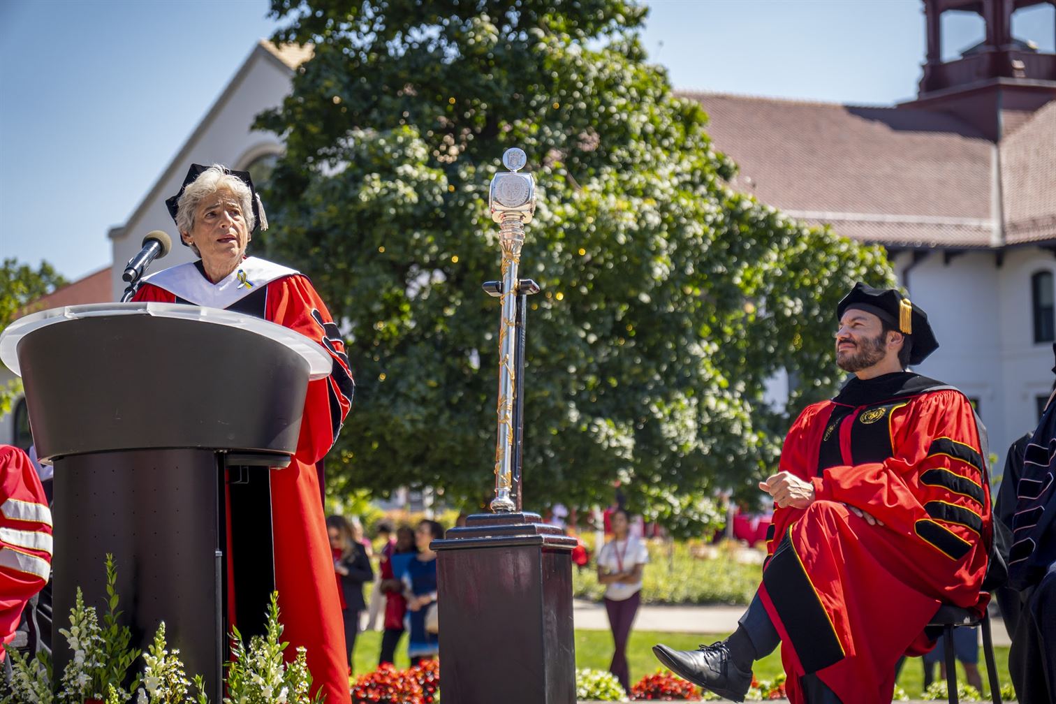 From left Former President Susan Cole speaks as President Johnathan Koppel listens to her in between the university mace. Lynise Olivacce | The Montclarion