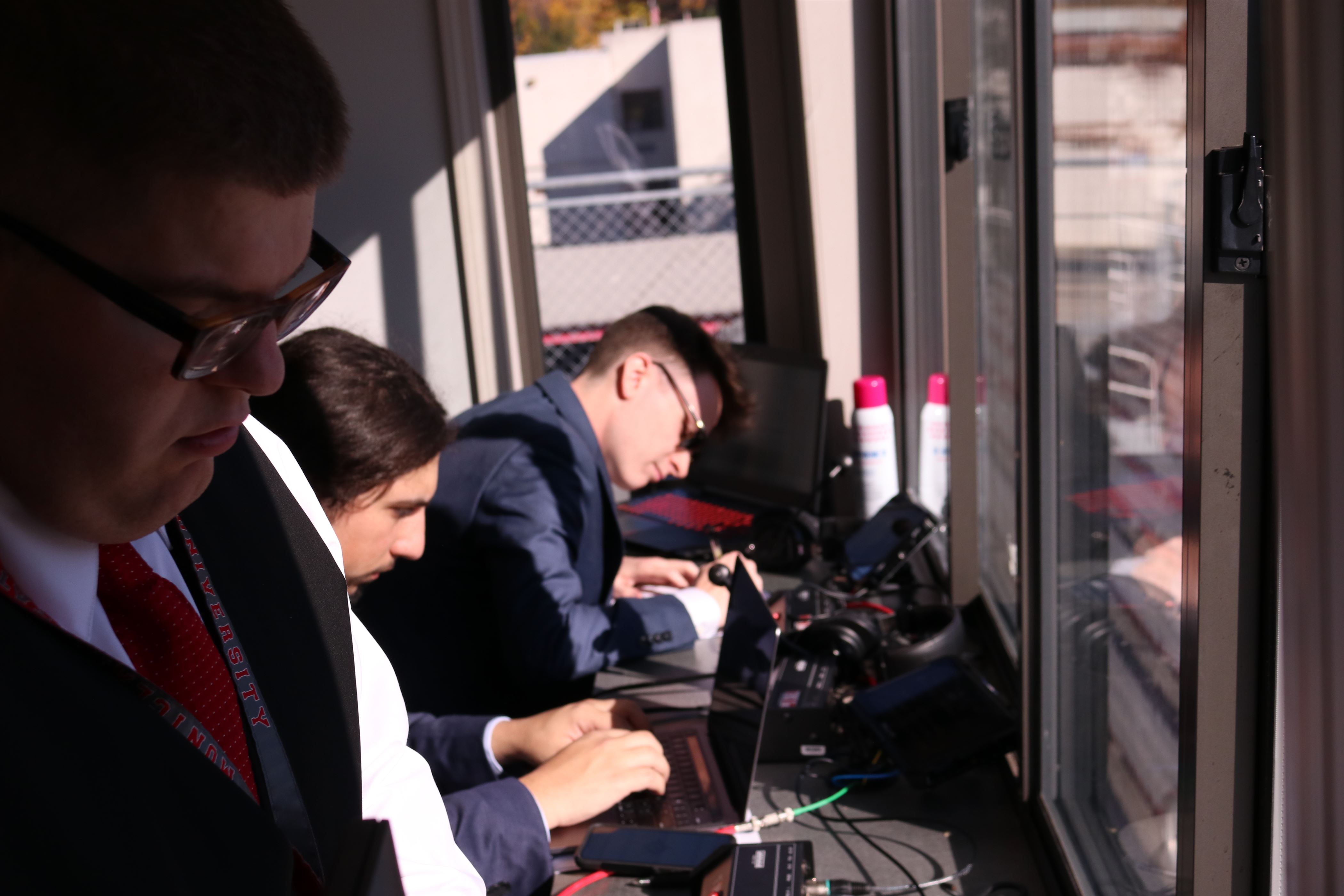 Commentators Campbell Donovan (close left), Anthony Cafone (middle), and Charlie Baduini (right) prepare for the football game. Photo courtesy of Wyatt Lardieri