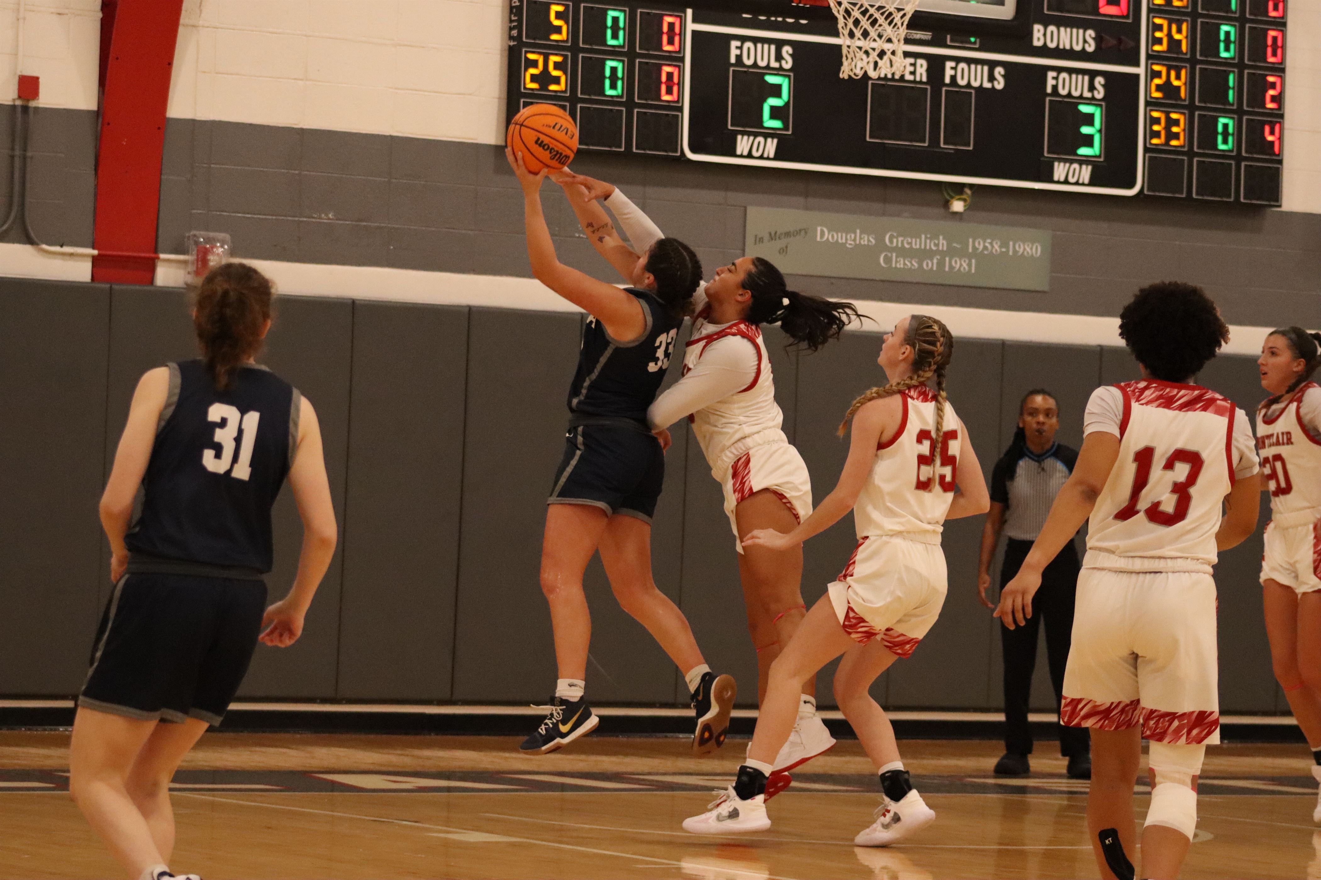 Olivia Vero goes for a block from behind the Ithaca player. Dan Dreisbach | The Montclarion
