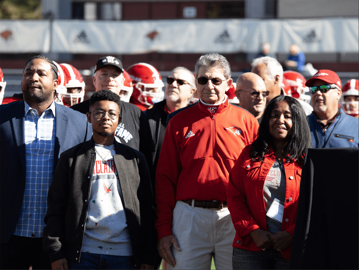 Melanie Mills, Sam Mills III and Rick Giancola stand together during the pregame ceremony. Brie Killeen | The Montclarion