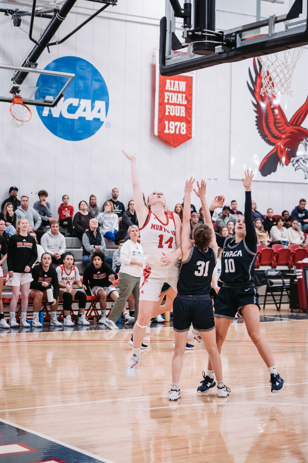 Nickie Carter scores a layup over two Ithaca defenders, which helped her secure the milestone. Dan Dreisbach | The Montclarion
