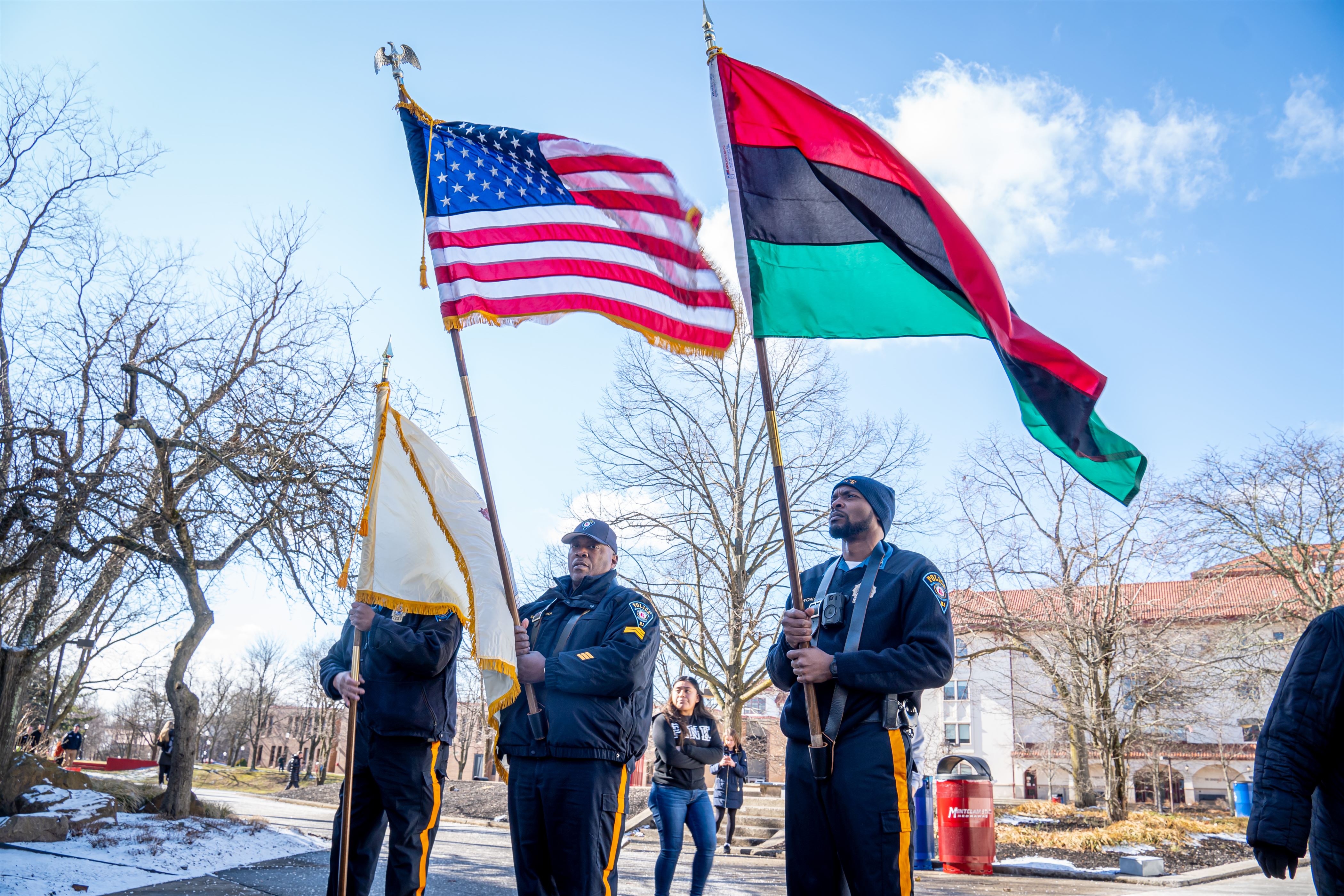The university police department waves the Pan-African flag, American flag and the New Jersey Flag, once they arrive at the student center flag poles. Lynise Olivacce | The Montclarion