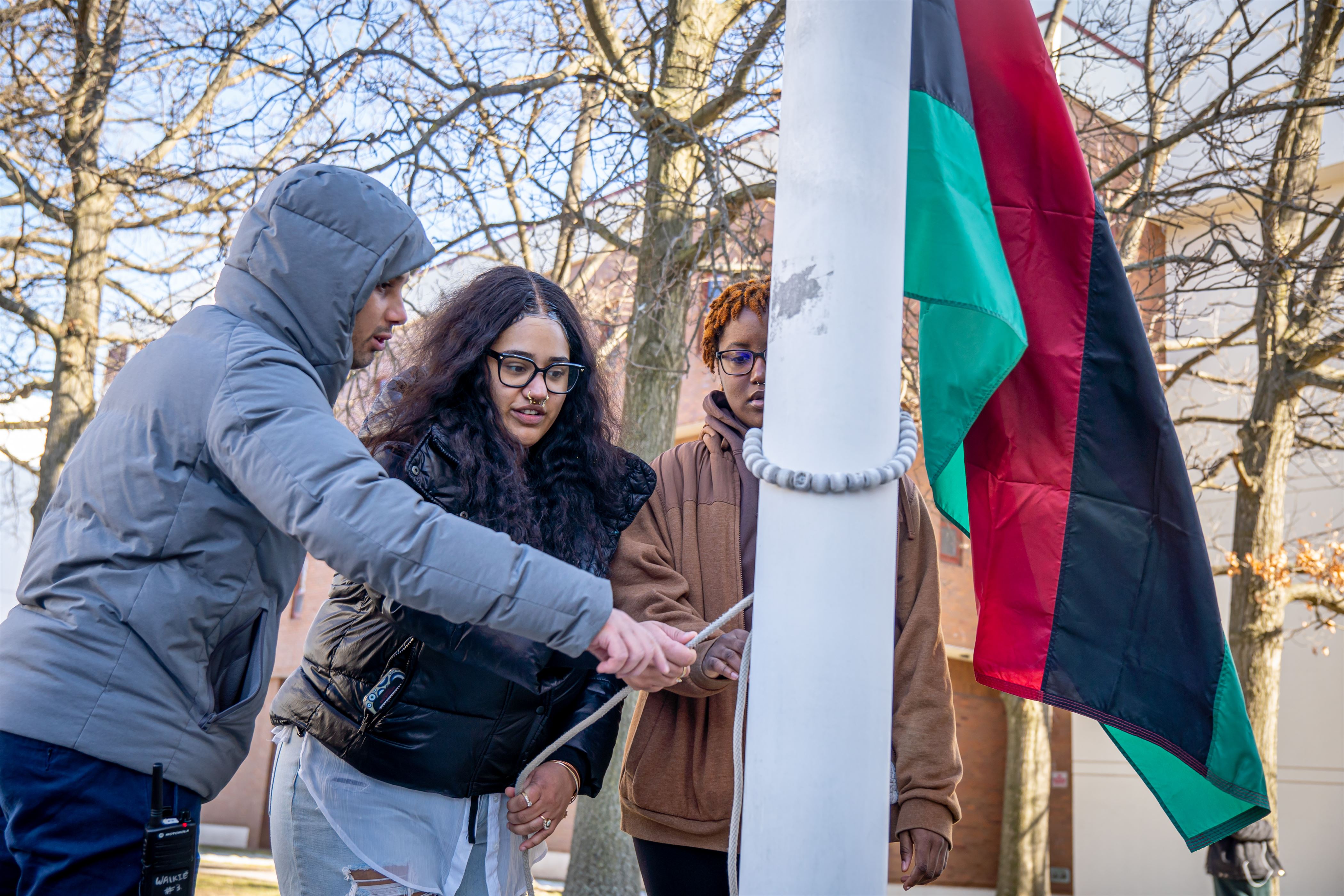 Eyv Matthews, a sophomore psychology major and the president of the Black Student Union, raises the flag at the Student Center flagpoles. Lynise Olivacce | The Montclarion