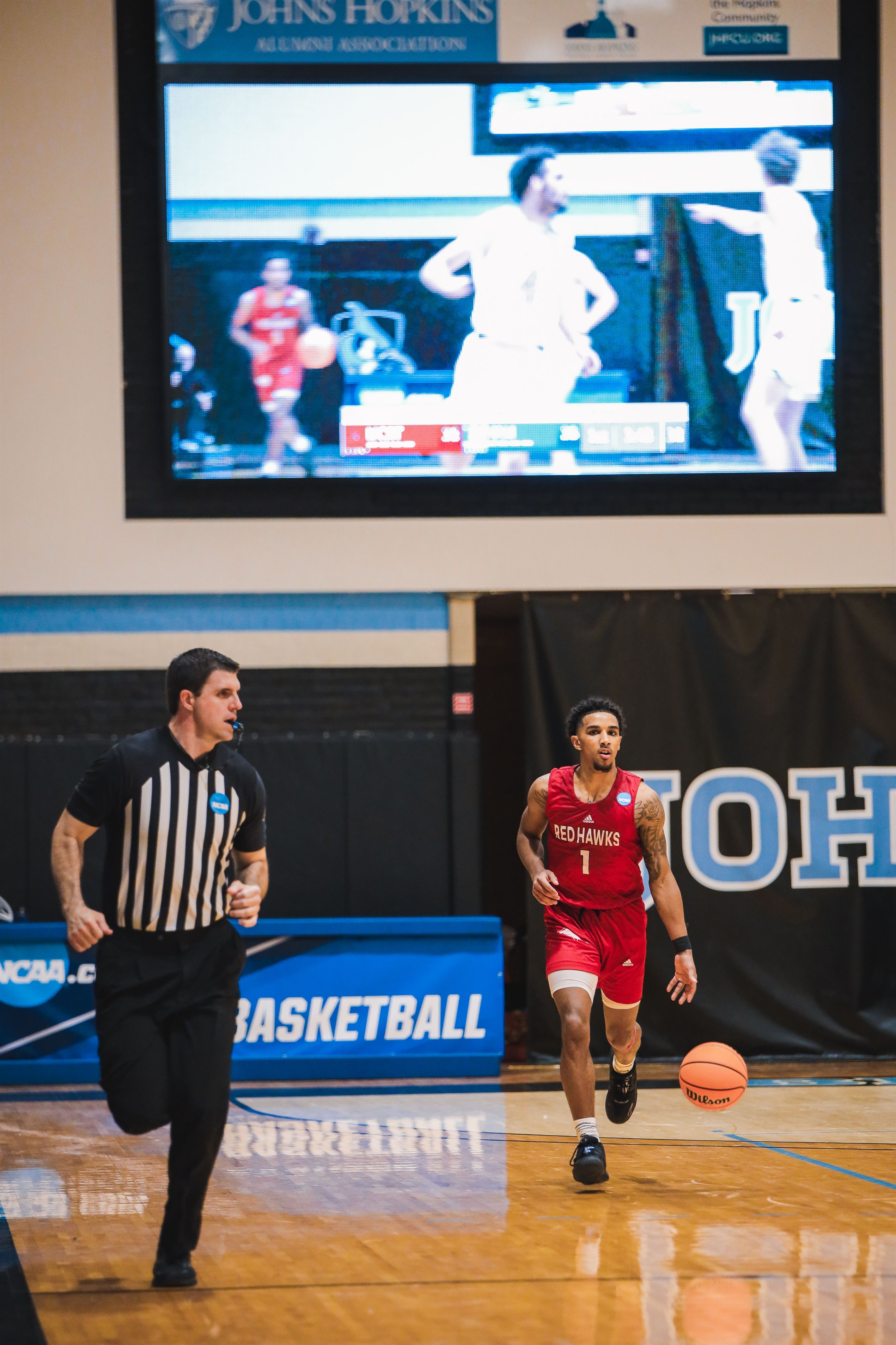 Senior guard Keyon Pryce takes the ball down with the live stream of the game behind him. Photo courtesy of Markell Robinson.