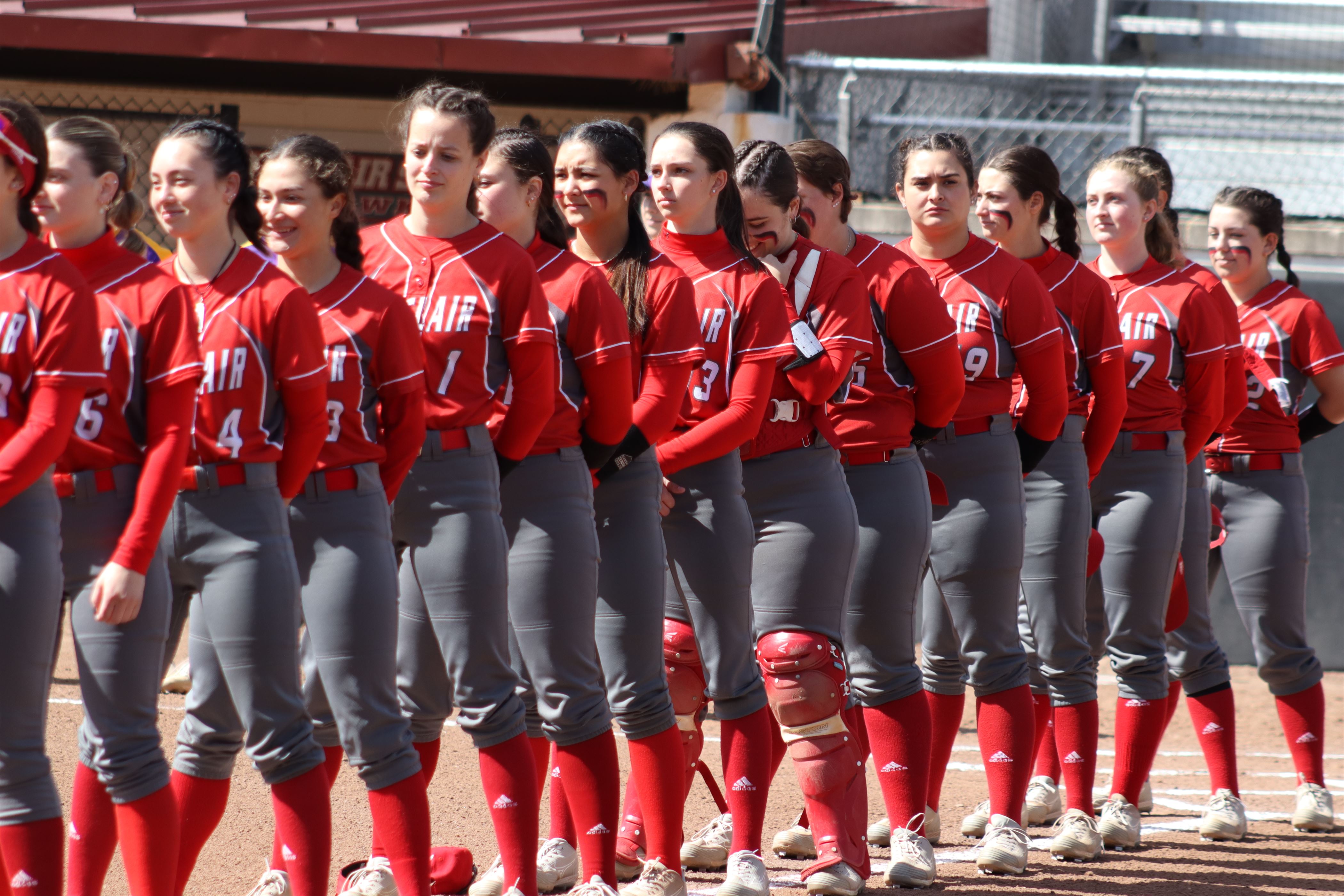 The Montclair State softball team stands for the national anthem before the game. Trevor Giesberg | The Montclarion