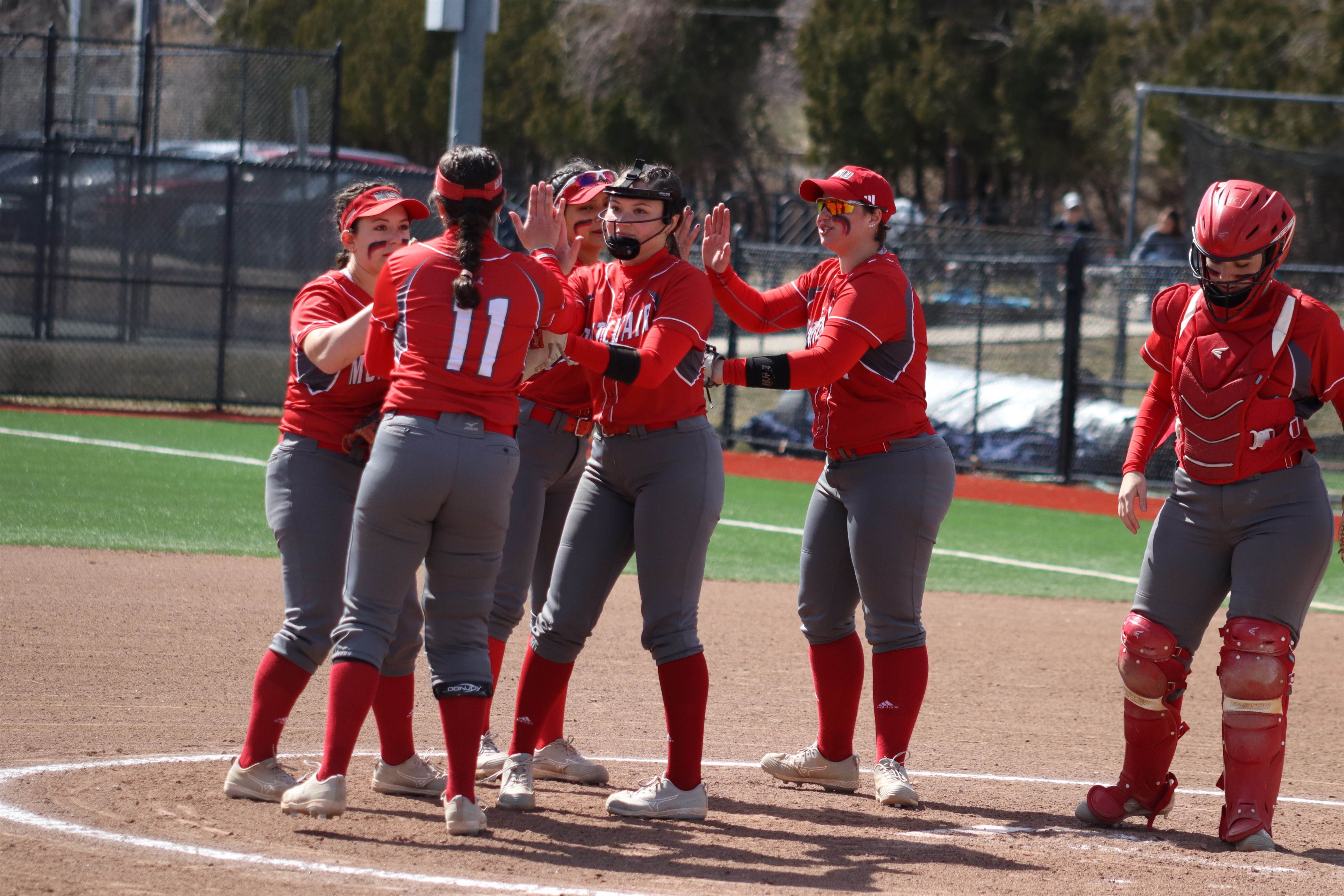 The Red Hawk infield huddles up and high fives each other during the game. Trevor Giesberg | The Montclarion