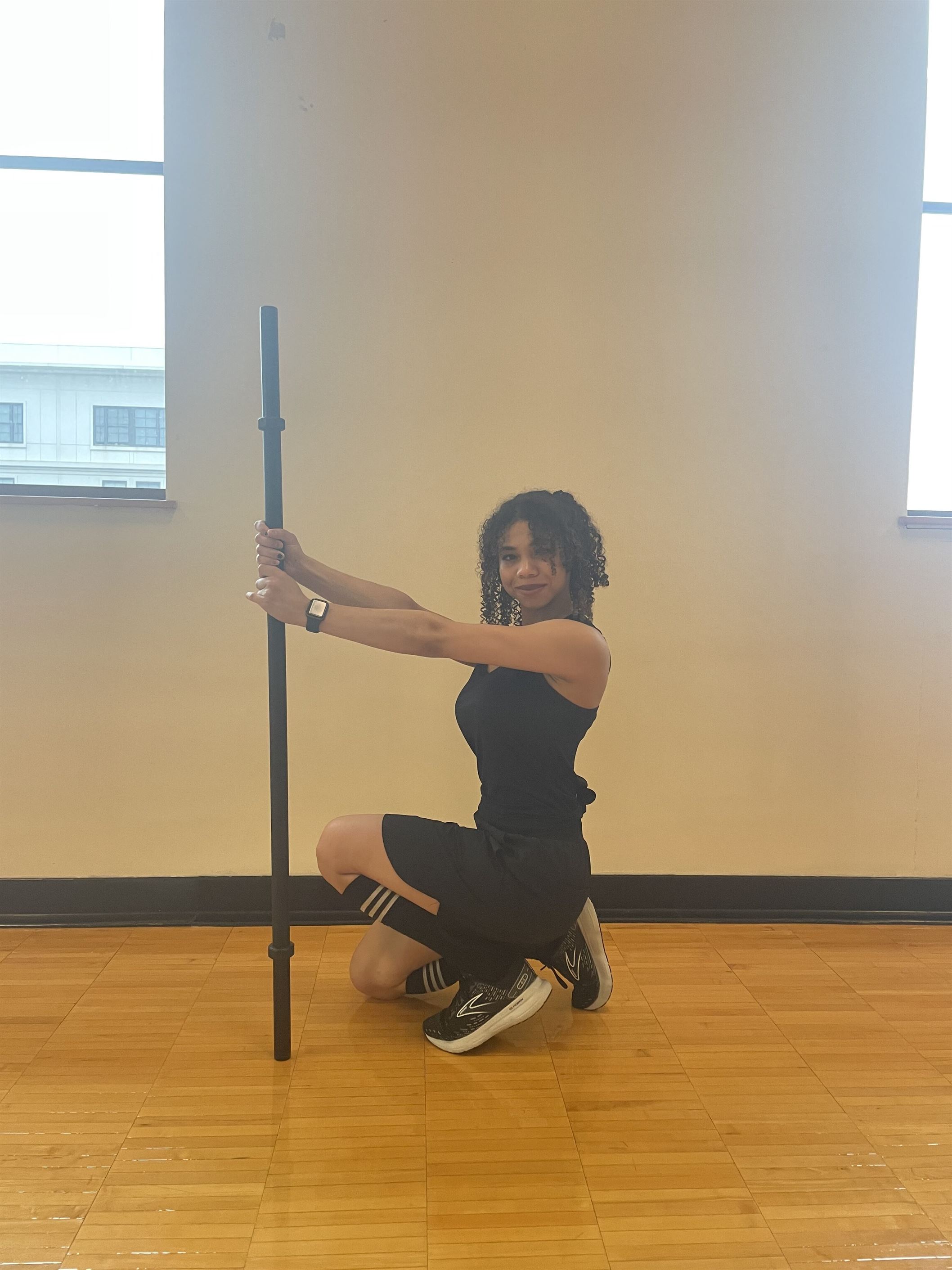 Senior linguistics major Mirit Fournier poses with a barbell during an UpLIFT session.