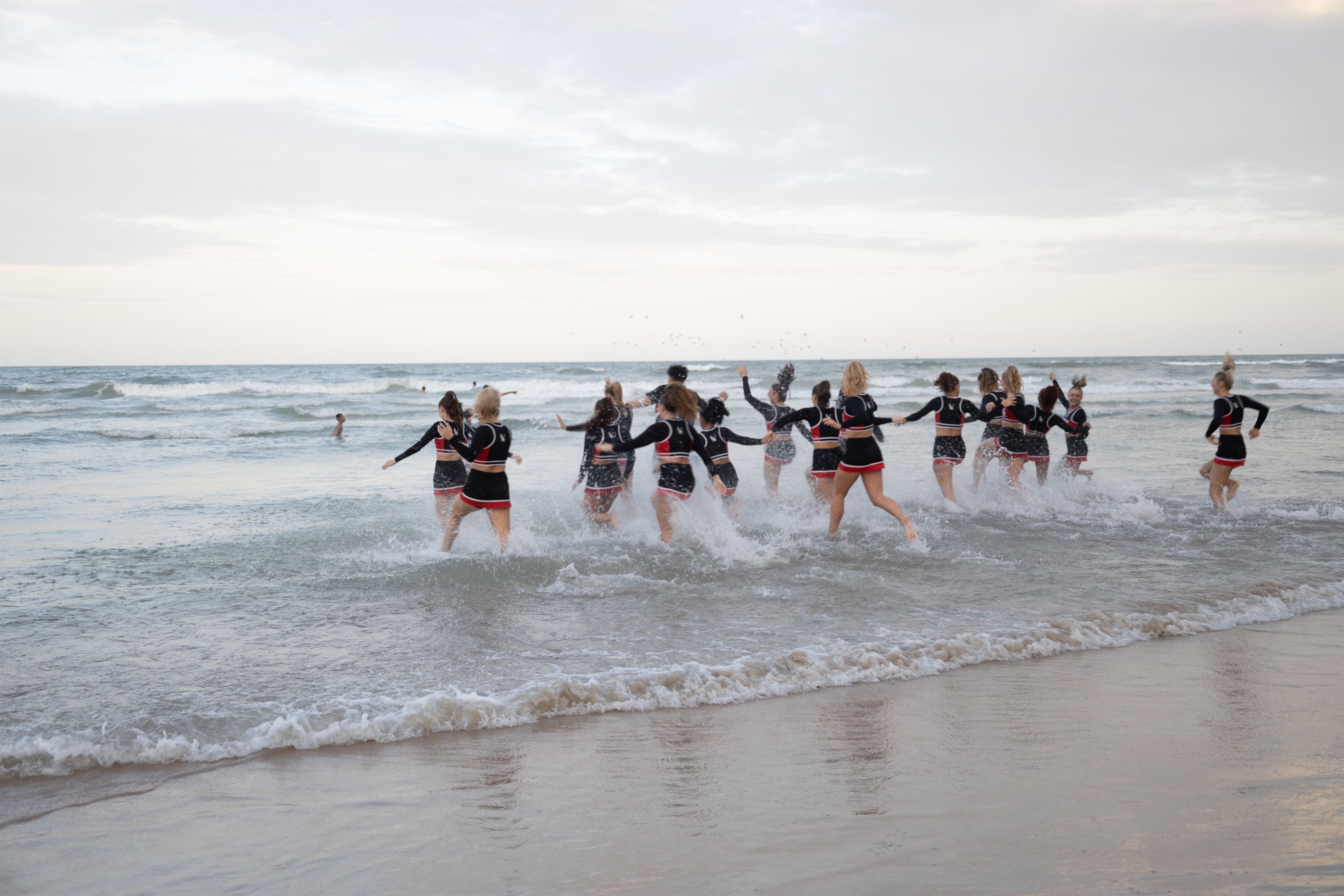 The cheerleading team runs out into the water to celebrate their win. Photo courtesy of Montclair State Cheerleading.