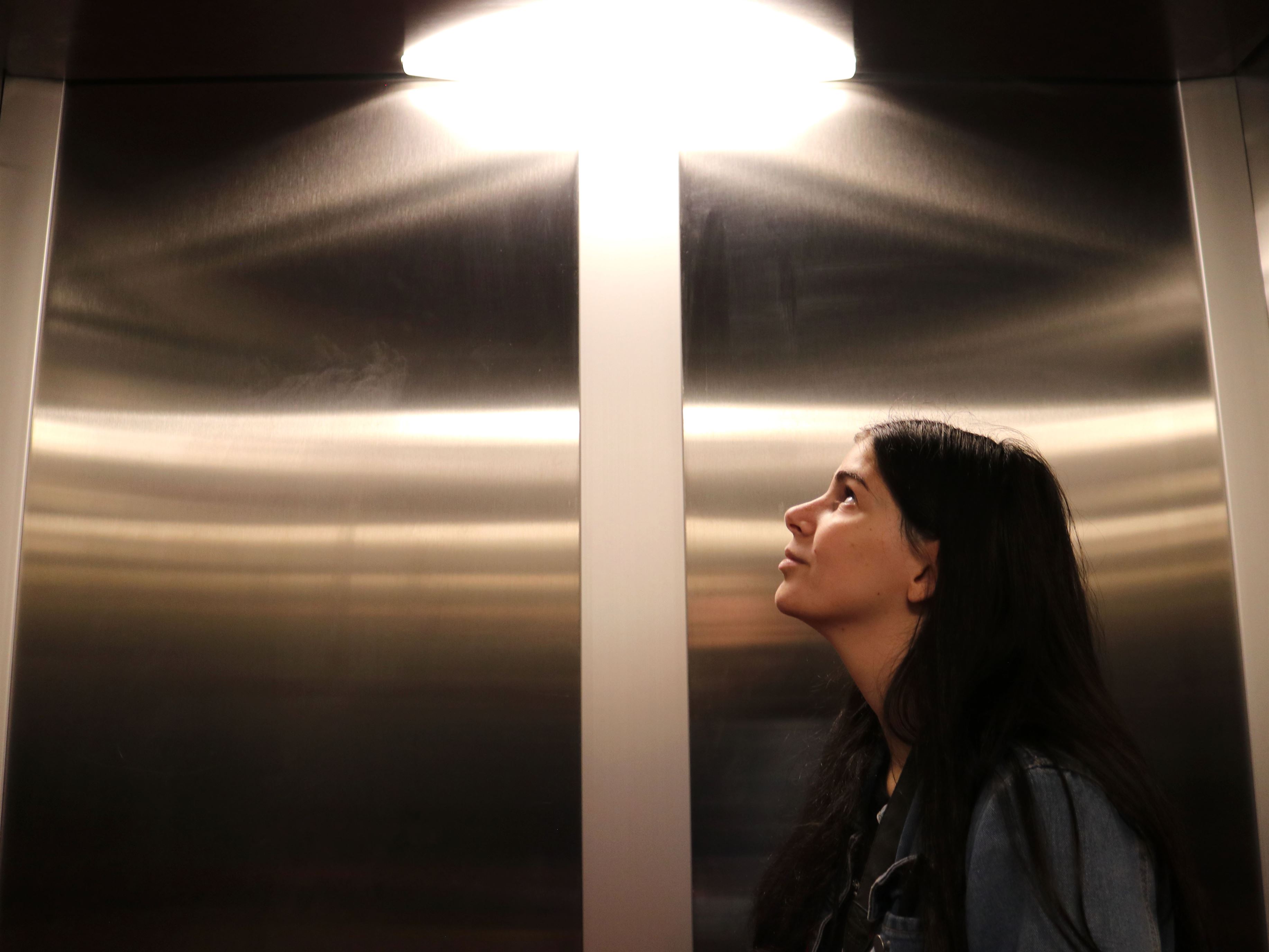 Ava Pierini, a freshman attending Montclair State University riding the elevator down on a Thursday morning in the School of Communication and Media to go to her multimedia class. The light from the ceiling draws the focus to the subject's face as that's where it lands. 
Photo courtesy of Elizabeth Beckley
