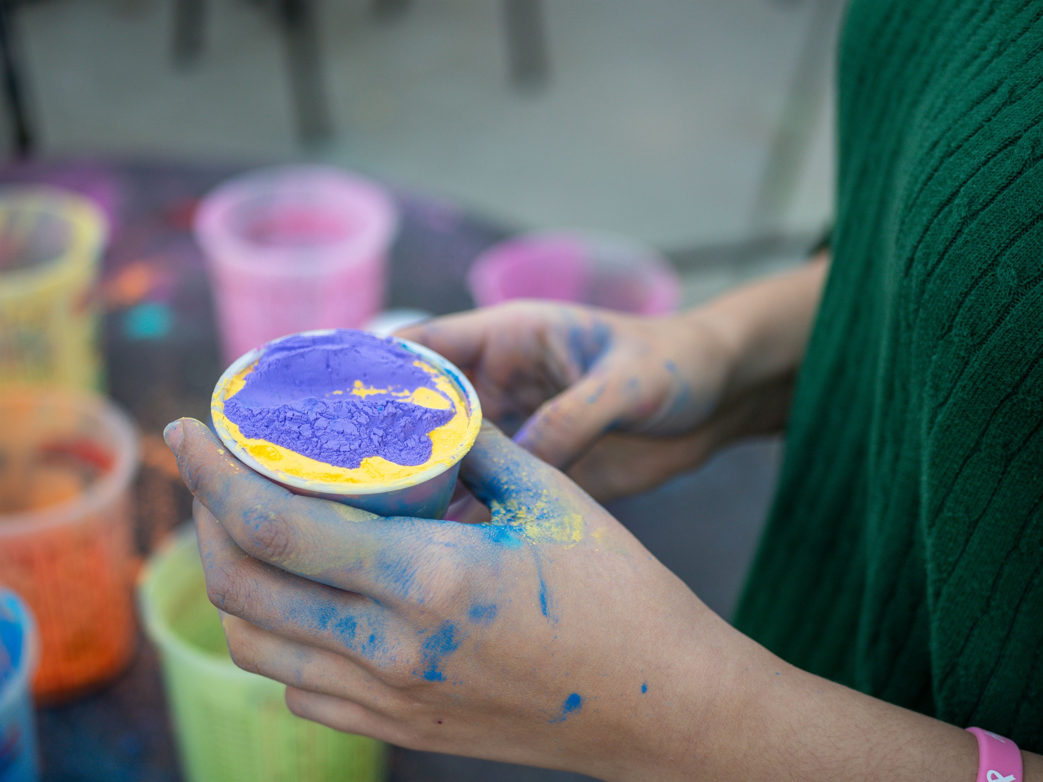 A student preparing paint mixture to throw in the air at the Cancer Awareness Walk event. Photo courtesy of Maral Tutunjian | The Montclarion