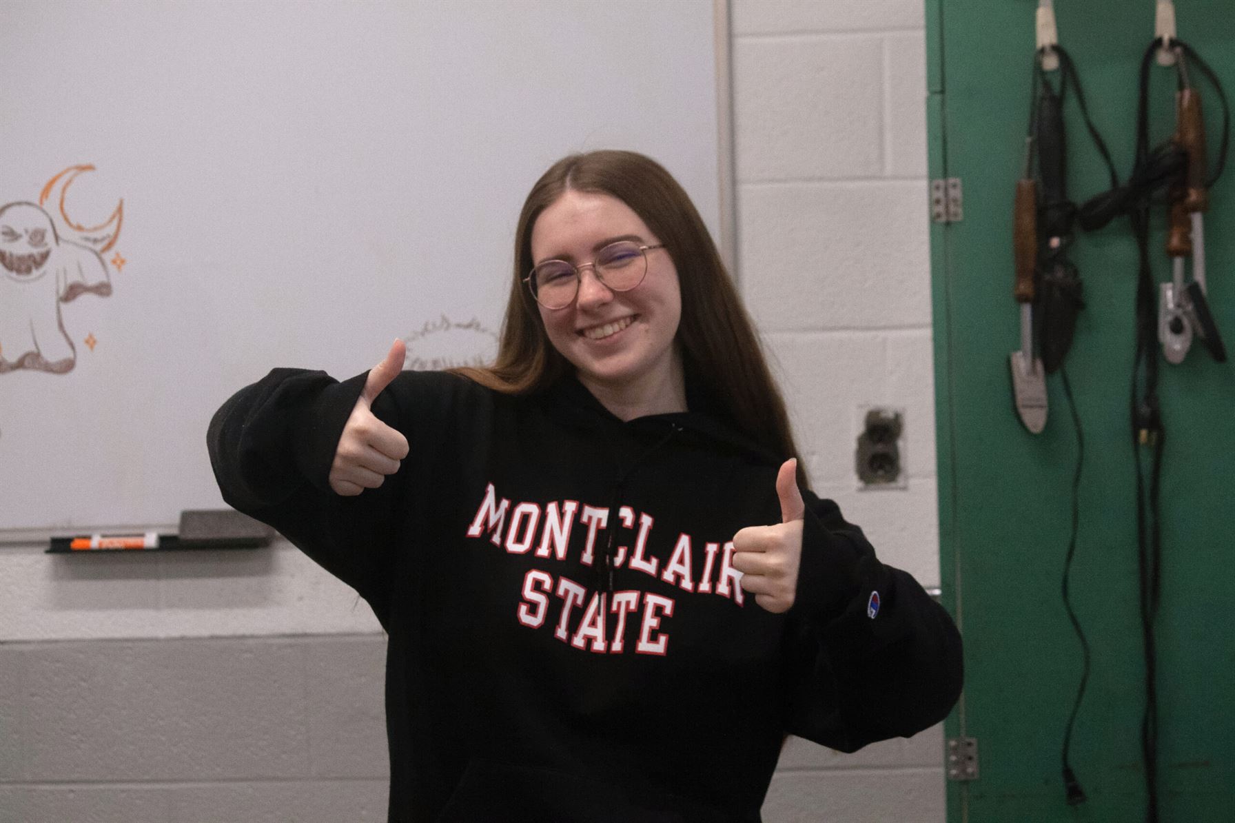 Maggie Evans, president of the photography club, poses with two thumbs up. Photo courtesy of Angel Santos