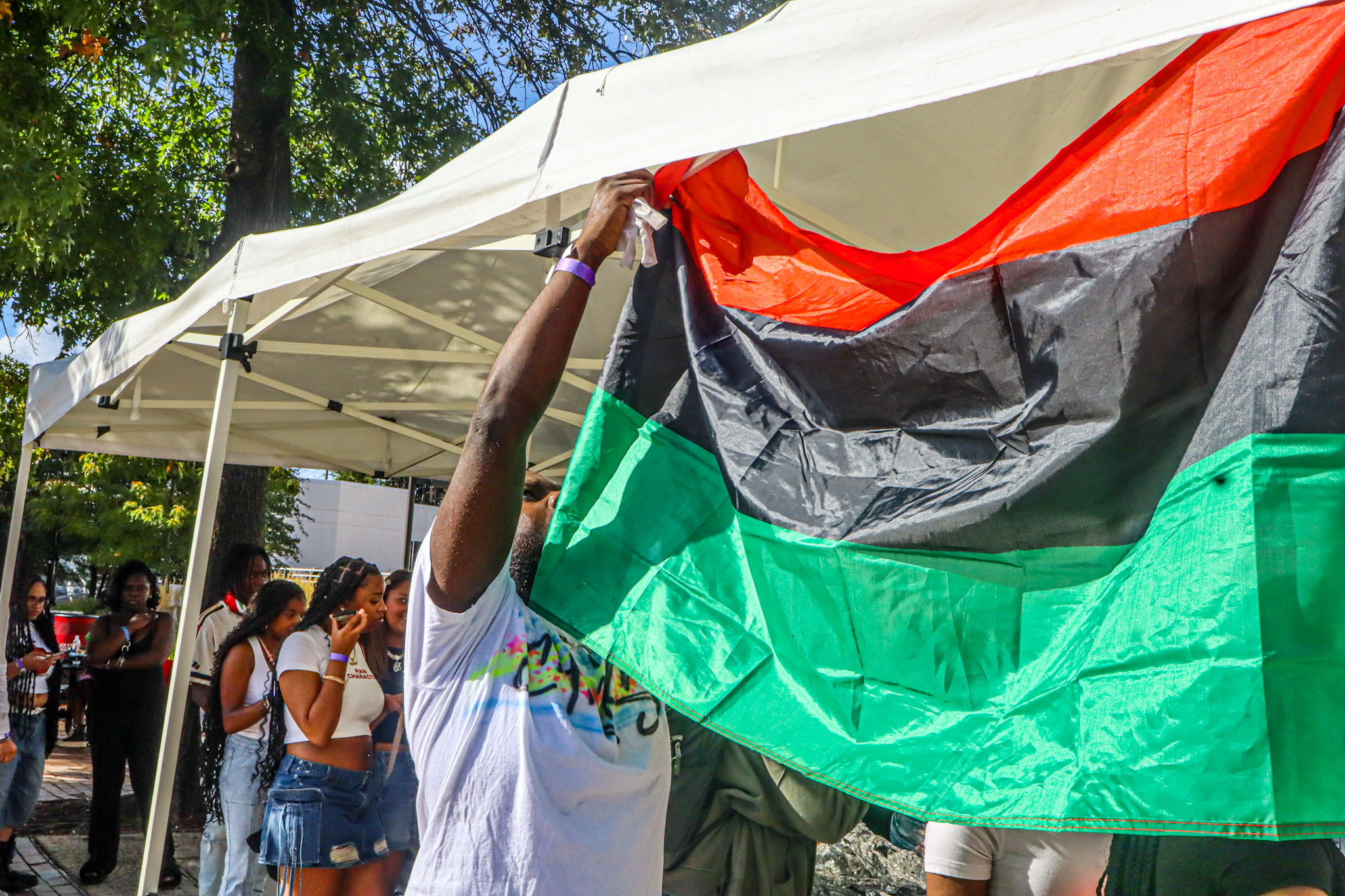 BSU President, Christian Warren hanging up Pan-Africanism flag. David Bien-Aime┃The Montclarion