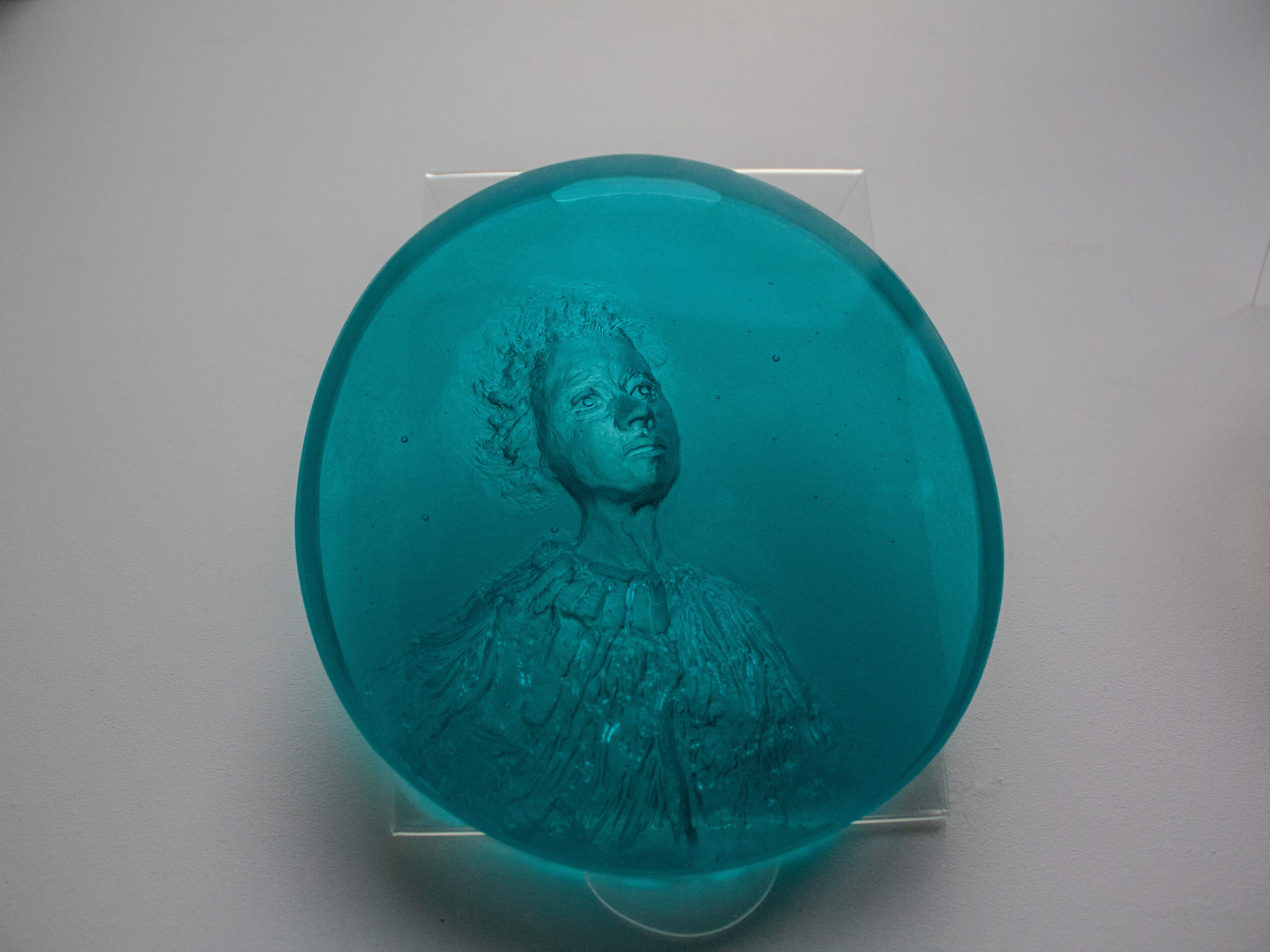 Holly Wilson’s glass medallions depicting a person [left] and a milkweed stalk [right]