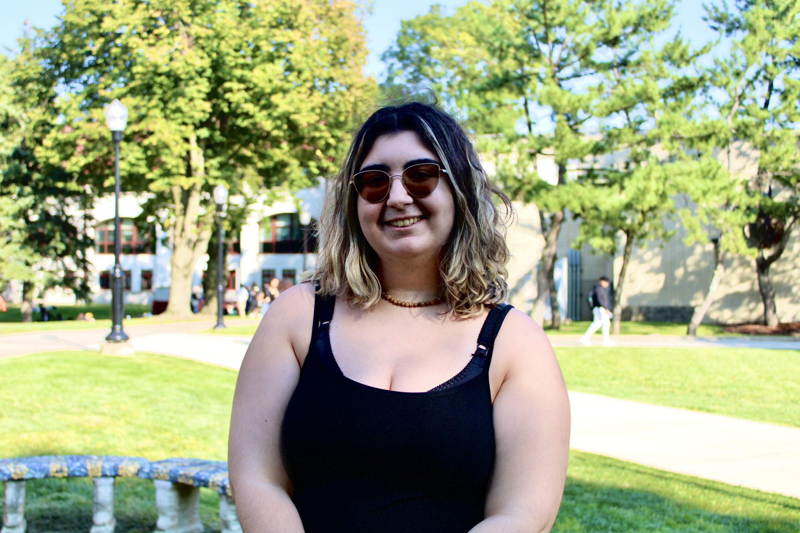 Simone Lino poses near a fire pit on campus.