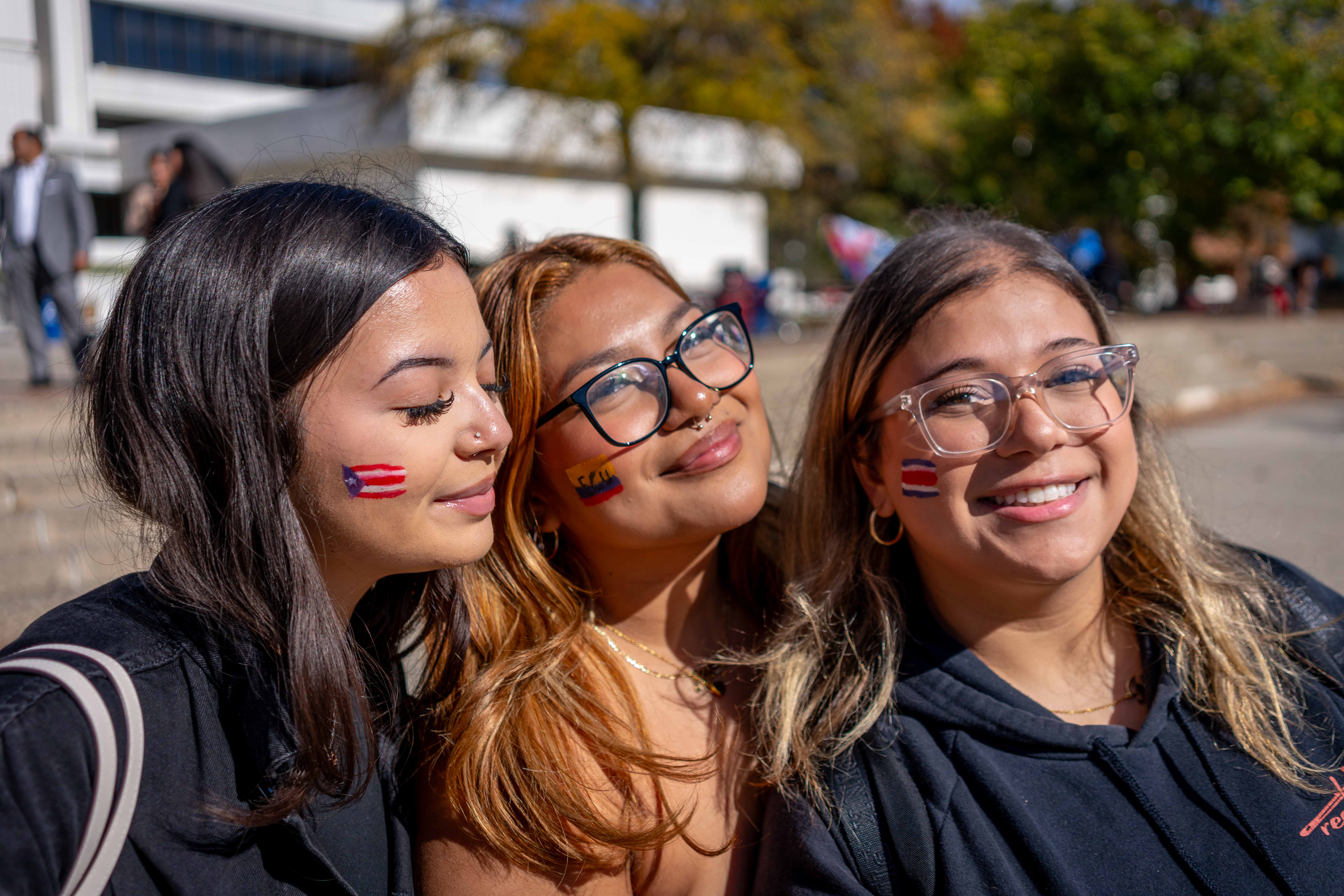 Three students pose for a portrait, showcasing their flag face paint at the Hispanic Heritage Month 2024 Block Party on October 16th, 2024. Karsten Englander | The Montclarion