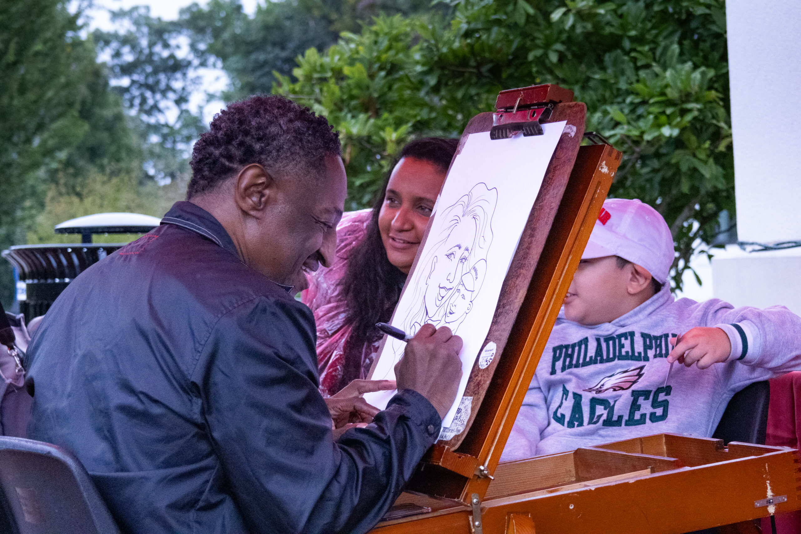 An artist making a caricature of 2 guests outside Cole Hall. Allen Macaraeg | The Montclarion