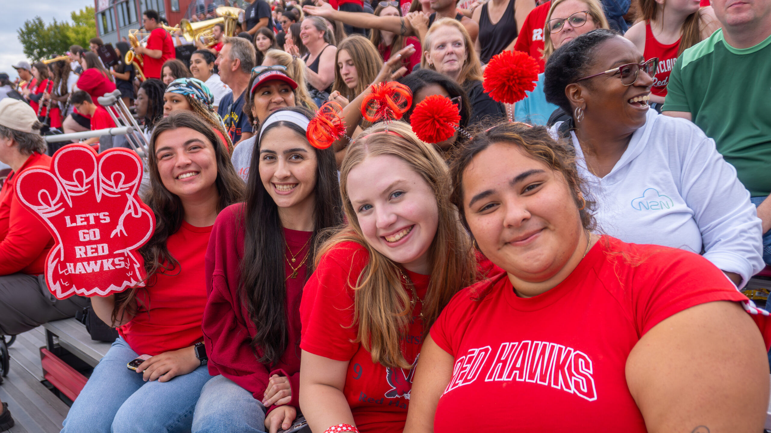 Students show pride in the stands as they cheer on fellow Red Hawks.