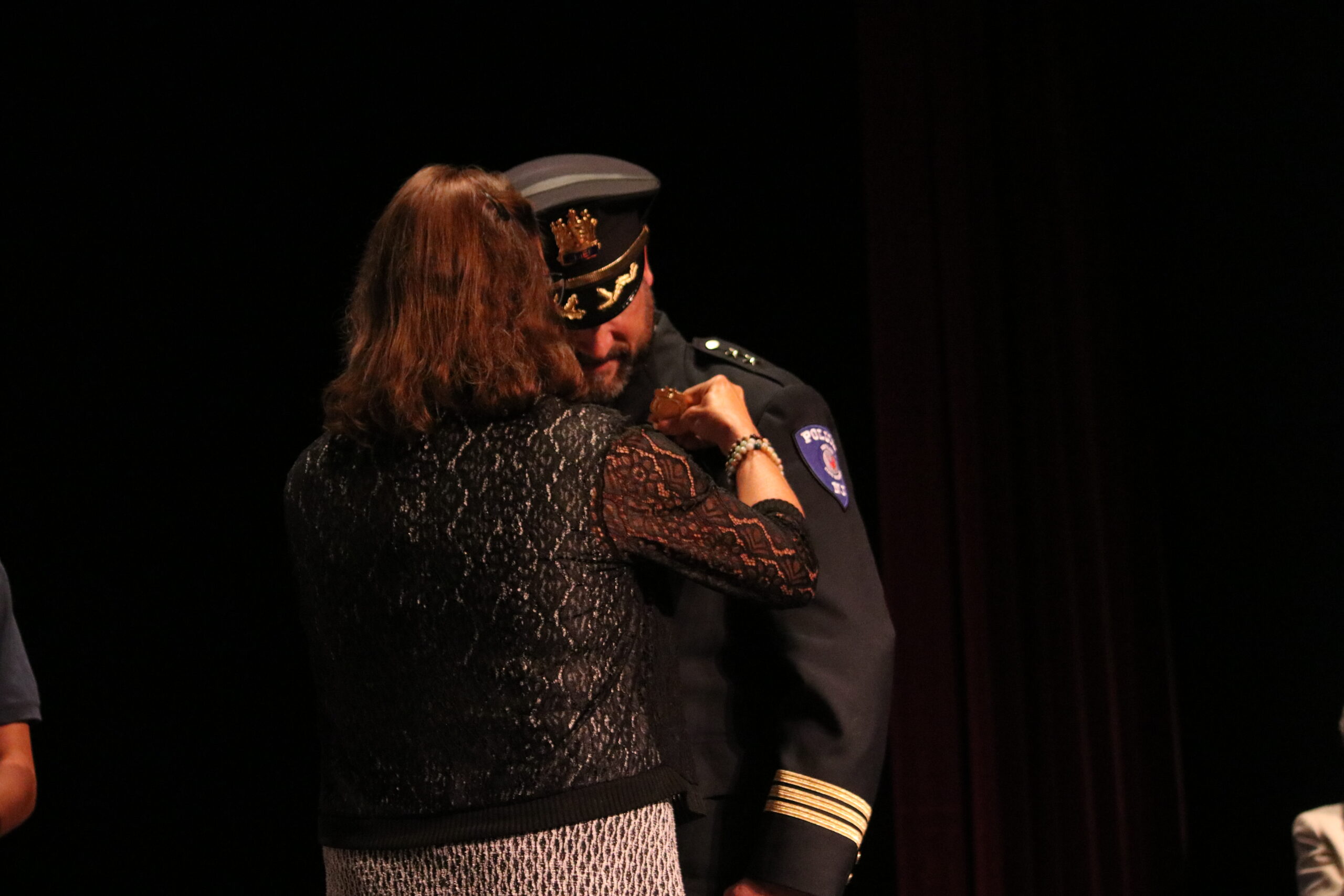 Dr. Dawn Soufleris, the vice president of Student Development and Campus Life attaching a badge to Timothy Fox, the new chief of police at his swear-in ceremony.