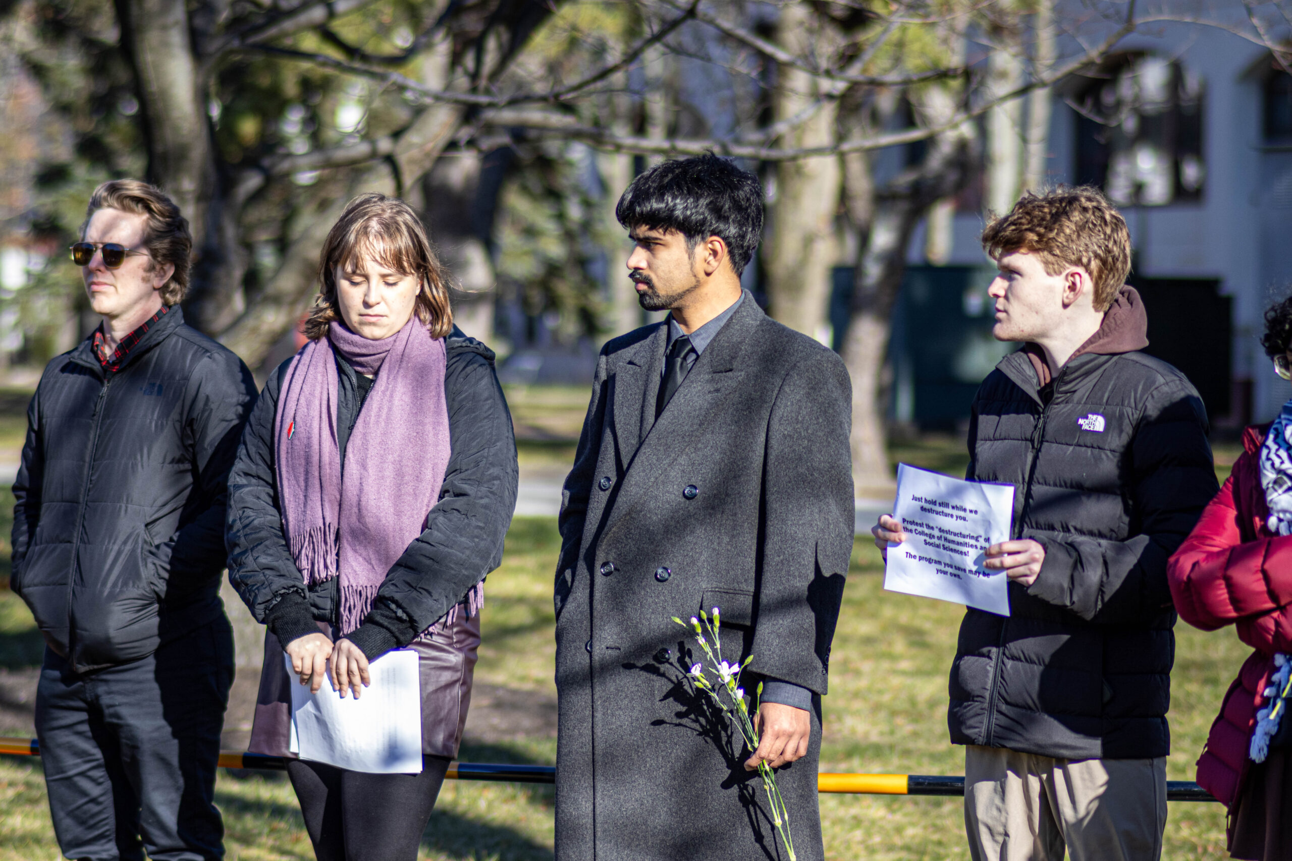Students at the mock funeral protest of the restructuring of the College of Humanities and Social Sciences, holding signs and flowers to symbolize the "death" of the college.
