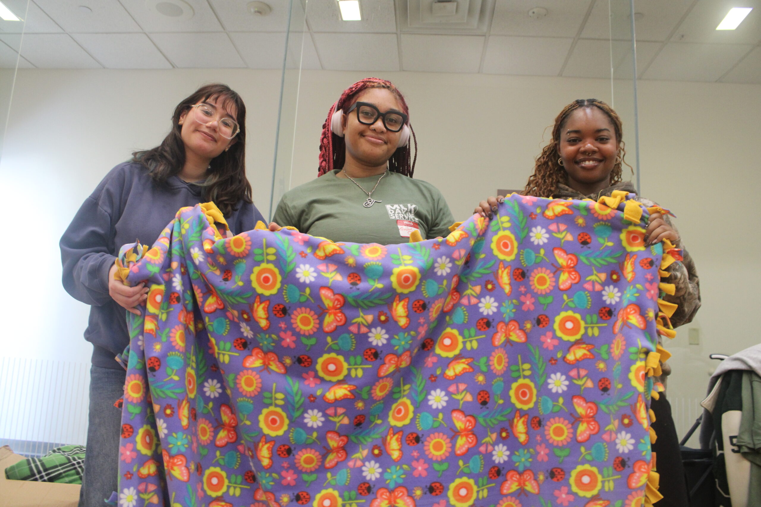 Students showcasing the finishing product of a blanket that they plan on giving back to the community. Jack Takouezim | The Montclarion