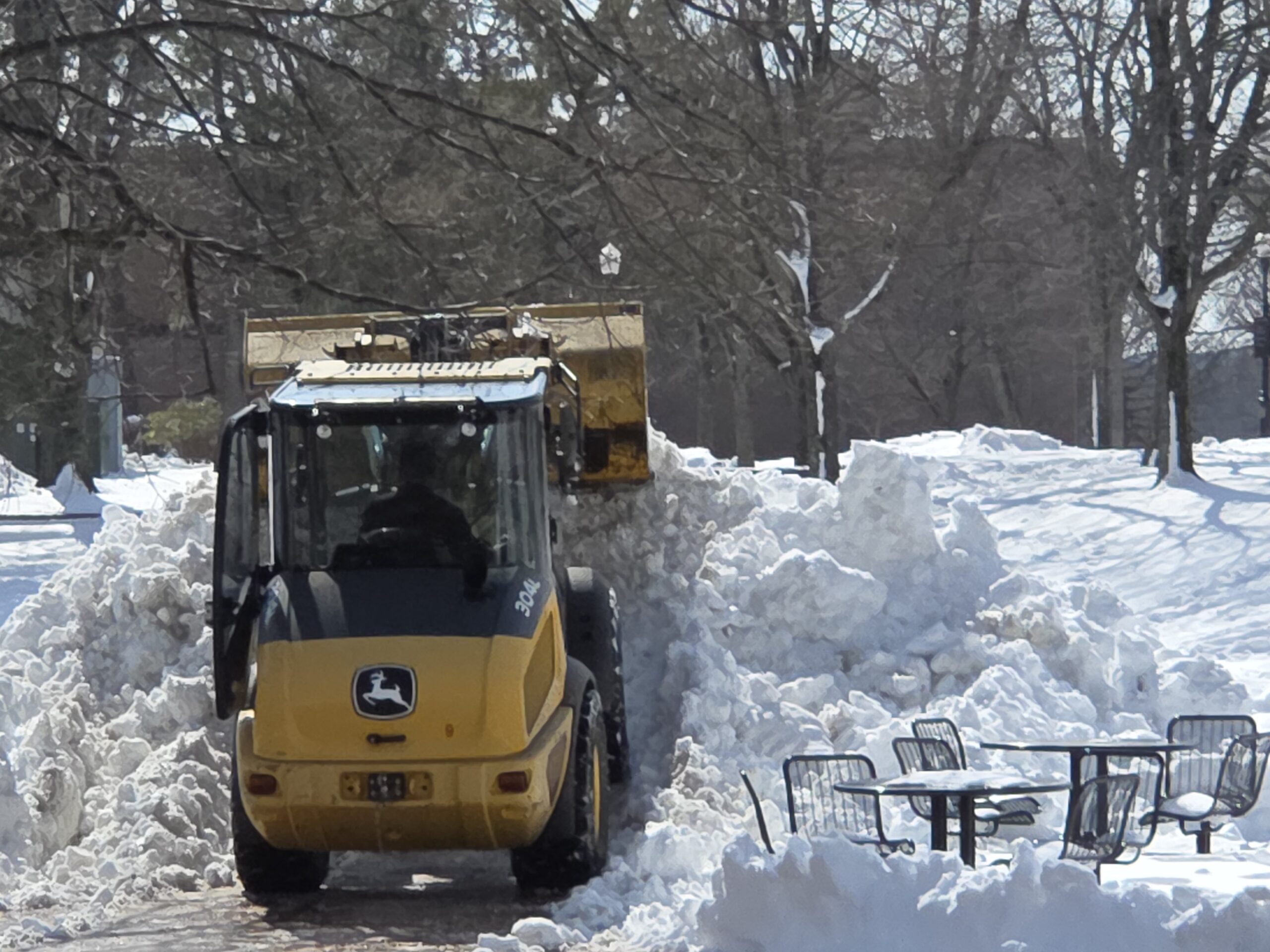 A small loader deposits scooped up snow at the north edge of the Student Center Quad on Feb. 25.
