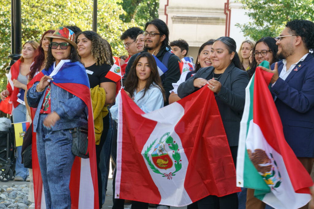 Students gather to watch hispanic heritage month flag raising ceremony while displaying their flags, Wednesday, Sep. 16, 2026.