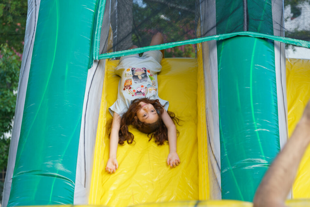 A girl slides down an inflatable slide upside down, Saturday, Oct. 3, 2026.