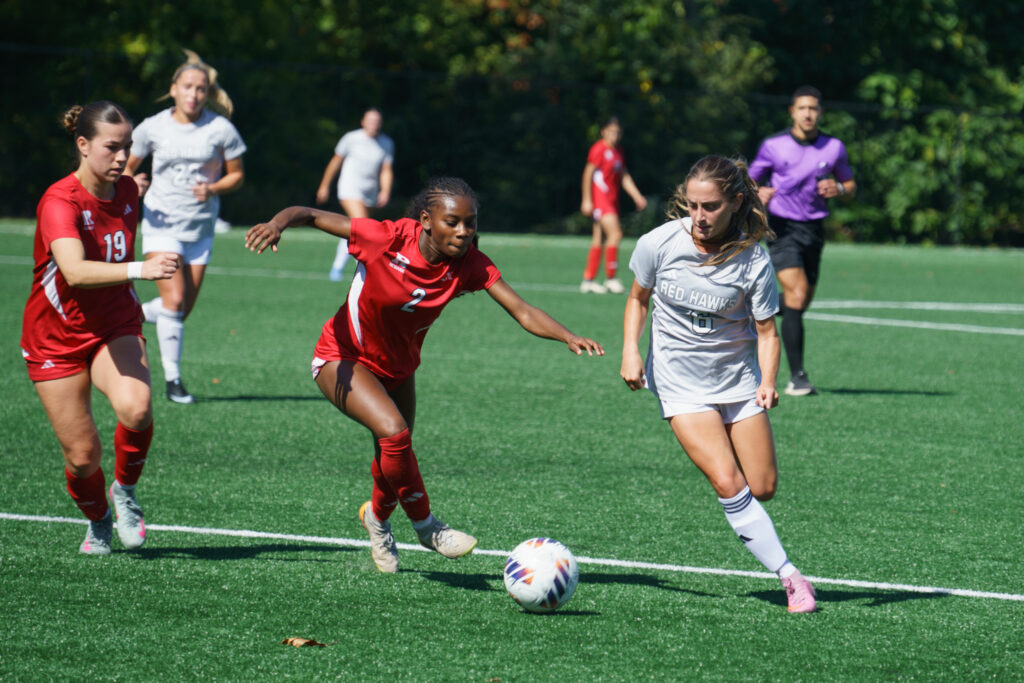 Lauren Vinella maneuvers around two opposing defenders during the homecoming game, Saturday, Oct. 3, 2026.