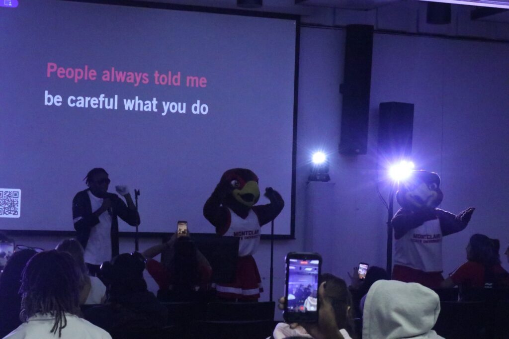 A student sings a song by Michael Jackson while students record him performing. Rocky and Roxy are dancing along to the singing.
